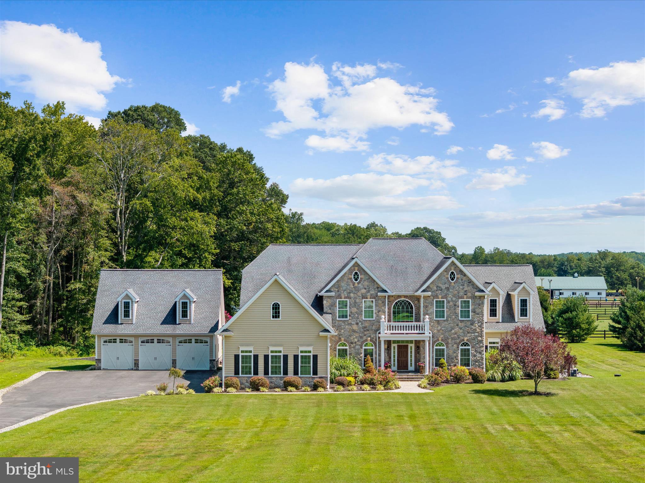 A Custom-Built Estate in Deale, Maryland – Where Grandeur Meets Comfort
Welcome to a one-of-a-kind custom estate boasting nearly 10,000 square feet of exquisitely designed living space on 5.59 private acres. This architectural masterpiece offers 7 bedrooms, 5.5 bathrooms, and an array of refined amenities that seamlessly blend elegance, function, and lifestyle. From the moment you enter the perfectly manicured drive, the home commands attention with its stone-and-siding façade and sprawling presence. Parking is effortless with an attached 3-car garage, complemented by an additional detached 3-car garage for car enthusiasts or extra storage. Step inside the dramatic two-story foyer, where a timeless staircase makes a grand impression. To the left, a formal dining room sets the stage for elegant gatherings; to the right, a refined living room exudes warmth. The true showstopper awaits in the great room: soaring 20-foot coffered ceilings, a striking stone fireplace that echoes the home’s exterior, and an expanse of windows framing breathtaking views of your private resort-style backyard. Outdoors, every day feels like a retreat. Dive into the sparkling saltwater pool with attached spa, or let the kids make a splash down the slide. Entertain under the shaded cabana, gather around the outdoor fireplace on crisp autumn evenings, and enjoy endless seating areas designed for relaxation and celebration. The gourmet kitchen is a chef’s dream, anchored by a grand center island and equipped with dual ovens, a gas cooktop, walk-in pantry, and an elegant Butler’s pantry. A main-level office provides serene backyard views, while the sunken Florida room floods with natural light—perfect for morning coffee or unwinding with a book. You’ll always be comfortable with the brand new (2025) HVAC units, yes! All three have been replaced! Upstairs, five generously sized bedrooms and four full bathrooms offer comfort and privacy for family and guests. The primary suite is a sanctuary of luxury, with tray ceilings, a private balcony, a sitting area, and a spa-inspired bath featuring dual vanities, a glass-tiled shower, a soaking tub, and a private water closet. The pièce de résistance? A custom walk-in closet spanning the entire length of the 3-car garage—an unrivaled space designed to impress. The lower level extends the living space with a fully finished basement, complete with a kitchenette, bar area, two additional bedrooms, and a full bath—ideal for an in-law suite, au pair quarters, or multigenerational living.
This Deale estate is not just a home—it’s a lifestyle. Whether hosting grand celebrations, enjoying quiet family evenings, or simply soaking in the beauty of your surroundings, this property offers it all. Located just 30 minutes south of Annapolis, 30 minutes to Washington DC & Northern Virginia it’s a commuters dream! Just 20 minutes to Joint Base Andrew’s.