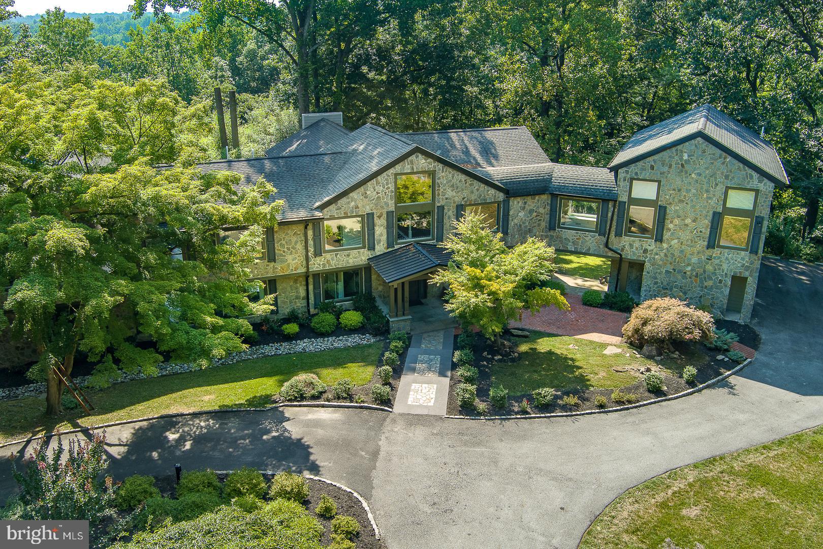 Stunning, brand new, open floor plan, 6 bedroom, 7 full bathroom, and one half bath custom built home on one of the most desirable streets in Penn Valley awaits! Sitting on a private, 2.78-acre interior lot, this 8000+ sq ft Transitional masterpiece has tons of oversized windows that infuse the home with light and picturesque views, wide-width hardwood floors, and gorgeous high-end finishes throughout that will not disappoint! As you enter, you will be immediately wowed by the grand kitchen and dining room that flow seamlessly into the fantastic, enormous, 2-story great room with exposed beams, floor-to-ceiling stone, gas fireplace, and access to the serene back deck, yard, and spectacular swimming pool area. The chef’s kitchen features a massive Quartz waterfall island, custom wood cabinetry, two sinks, two dishwashers, and high-end stainless steel appliances. Two-bedroom suites with full ensuite bathrooms, an office, and a half bathroom complete this level. Ascend the open stairs to the 2nd floor, where you will find two generous-sized primary suites. The first suite has a vaulted ceiling, built-ins, a custom walk-in closet, and a full ensuite bathroom with separate vanities, a soaking tub, and a large walk-in shower. The 2nd primary suite also has a vaulted ceiling, with loft space, which is perfect for an office or sitting area, a walk-in closet, and a full ensuite bathroom with two vanities and an enormous walk-in shower. There is an additional bedroom suite on this level with a full bathroom and tub, a laundry room, and a fabulous, grand theatre room with another full bathroom. The finished, walk-out lower level offers tons of additional living space and could be used as an au pair or in-law suite with a private entrance, a bedroom with a walk-in closet, a full bathroom, another laundry room, and a large family/playroom. The lush grounds offer tons of privacy whether you are playing in the yard, relaxing with a book on the front patio, enjoying dinner al fresco, or taking a dip in the pool. It is located in the Award Winning Lower Merion School District. Close to all Narberth and the Village of Gladwyne have to offer. Easy commute to major roadways, 76, and Center City. This residence is a true gem and in complete move-in condition!