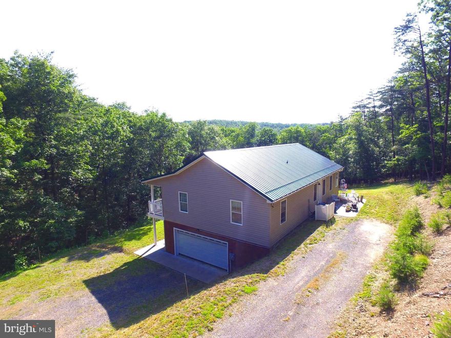 Step into this stunning 4-bedroom, 3-full-bath home with over 2600 square feet of living space, nestled on 2.26 acres of serene, secluded land. Built just four years ago, this thoughtfully designed home boasts spacious rooms, elegant laminate plank flooring throughout, and beautiful cabinetry that adds warmth and character. Accessibility is a priority with 32" wide doorways and a 36" wide hallway and stairway, ensuring comfort and ease of movement.
Enjoy the tranquility of nature from multiple outdoor spaces, including a covered porch on the main level, a covered patio on the lower level, and a charming front patio.  Perfect for relaxing or entertaining.   A picturesque wet weather stream meanders through the property, enhancing its peaceful charm.
The heart of the home, the kitchen, is a chef’s delight, featuring an abundance of cabinets and counter space, perfect for cooking and gathering.  Natural light pours into every corner, creating an inviting atmosphere throughout. The walk-out basement offers additional space and versatility to suit your lifestyle.
This exceptional property blends modern convenience with privacy and natural beauty.  An opportunity not to be missed! Check out the 3D Tour!