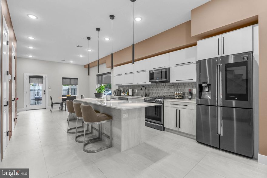 Experience modern city living in this exceptional residence, ideally located in Olde Kensington, just moments from Frankford Avenue in Fishtown and the Piazza in Northern Liberties. Offering  4,000 square feet of thoughtfully designed space, this home blends bold architecture with refined details, creating a one-of-a-kind property. The first floor makes an immediate impression with its open, loft-style layout, soaring 10-foot ceilings, abundant natural light from three exposures, and striking marble and granite finishes. At the heart of the home, the chef’s kitchen features a dramatic waterfall island that effortlessly transitions from everyday meals to stylish entertaining. Just beyond, a private courtyard combines steel, brick, and concrete elements to create a serene outdoor retreat—perfect for gatherings large or small. Secured off-street deeded parking spot is accessible through the rear gate for added ease and security. A custom glass-enclosed staircase anchors the home, connecting each level while enhancing the open, airy feel. The second floor has two spacious bedrooms, each complete with its own en-suite bath and contemporary finishes. The entire third floor is dedicated to the primary suite, designed as a private sanctuary with a spa-inspired bathroom featuring a freestanding soaking tub, a glass-enclosed marble shower, and dual vanities. Custom closet systems and built-in storage elevate both style and function. The lower level expands the living space with 9-foot ceilings and a flexible open layout that can serve as a home theater, fitness studio, or office. On top, the expansive rooftop deck offers sweeping views of the Philadelphia skyline. Other features include 2 HVAC systems and a high efficiency electric hot water heater. Tax abatement ends 12/31/2030. Taxes and square footage is the responsibility of the buyer to have verified independently.