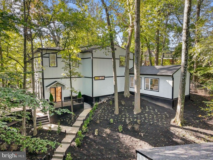 Soaring 11-foot ceilings fill this extraordinary Mid-Century Modern home with light and a true sense of openness. Nestled on over half an acre above the serene Sligo Creek, this Takoma Park gem seamlessly combines new-construction luxury with timeless architectural character. Enjoy park-like privacy, tree-framed views from every room, and effortless access to Sligo Creek Park trails. The property also features a two-car garage with an EV charger, a multi-car driveway and parking pad, providing both convenience and style.

Step inside to a welcoming foyer with floor-to-ceiling windows that open onto tiered decks overlooking the creek, making a breathtaking first impression. The main level is designed for modern living and entertaining, offering two bedrooms, two full baths, and a gourmet kitchen complete with a waterfall island, step-in pantry, and beverage bar. Two inviting porches provide tranquil park vistas, while a main-level laundry hook-up adds everyday convenience.

Upstairs, the primary suite impresses with vaulted ceilings, a dressing room, and a spa-inspired bath. Three additional bedrooms share a Jack-and-Jill bath, complemented by a second laundry area for ultimate practicality. Multiple upper-level decks extend the living space outdoors, maximizing privacy and scenic views for effortless indoor/outdoor living. The conditioned lower level offers abundant storage or the opportunity to finish additional space to suit your lifestyle.

Set on a sidewalk-lined street, this home is just minutes from local favorites including the Takoma Park Co-Op, Takoma Bev Co, Farmer’s Market, and Cielo Rojo. With lush parks, lively festivals, and a welcoming community, this unique property offers the perfect blend of style, comfort, and convenience in one of the region’s most vibrant neighborhoods.

Mortgage savings may be available for qualified buyers.