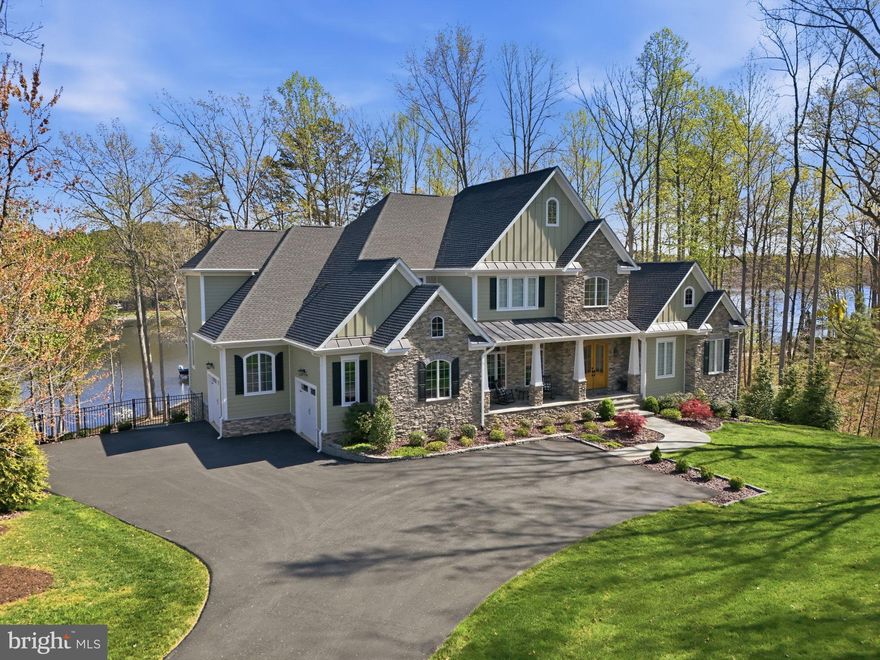 The epitome of waterfront living, this exceptional luxury Dream Home is nestled within Fawn Lake, one of Virginia’s most prestigious gated, resort-style communities.
Meticulously blending Modern Craftsman elegance with timeless architecture, this nearly new masterpiece by Warner Custom Homes offers over 8,200 square feet of exquisitely finished living space across three levels. Perched on a beautifully landscaped 1.50 acre peninsula lot with 367 feet of shoreline, the residence captures breathtaking panoramic water views while offering privacy, tranquility, and natural beauty. 
Designed to embrace the full allure of waterfront living, the remarkable Home showcases an effortless flow of light-filled spaces oriented to maximize the stunning lake views, creating an atmosphere where refined elegance and everyday comfort exist in perfect harmony. 
The thoughtfully designed floor plan balances expansive gathering spaces with intimate retreats, all enhanced by high-end upgrades and custom finishes throughout.
A soaring two-story foyer, anchored by a grand staircase with iron balusters, creates a striking first impression. Beyond, the spectacular Great Room features a dramatic wall of windows framing sweeping lake views, a two-story tongue-and-groove Coffered Ceiling, and a stunning limestone fireplace flanked by custom built-in media cabinetry.
The showstopping gourmet Chef’s Kitchen is beautifully appointed with custom cabinetry, granite countertops, a massive center island, and top-tier appliances, including a Wolf six-burner cooktop and separate Thermador refrigerator and freezer. Designed to accommodate both everyday living and grand-scale entertaining with ease.
Adjacent to the kitchen, a sunlit breakfast area with expansive windows offers captivating water views and seamless access to the oversized deck, perfect for seamless indoor-outdoor lakeside living.
The gorgeous formal Dining Room provides an elegant setting for entertaining, while a bright, inviting Morning Room with a wall of windows offers a  versatile space to relax and unwind.
The main-level Primary Suite is a true sanctuary, featuring a private sitting area with serene water views and a luxurious spa-inspired bath complete with a walk-in Roman shower, soaking tub, dual vanities, custom cabinetry, and an expansive walk-in closet with built-in organization and a dedicated dressing vanity.
Upstairs, a dramatic overlook captures sweeping lake views and leads to a second Owner’s Suite, along with two generously sized bedrooms with ensuite baths, each thoughtfully designed for comfort, privacy, and style. The open loft with a built in media center is perfect for movie nights. 
A spacious loft with a built-in media center provides the perfect setting for movie nights or casual gatherings.
The walkout lower level is equally impressive, offering exceptional space for entertainment and leisure. Highlights include a large recreation room with a custom wet bar and stone fireplace, a fully equipped gym, a home office, and an additional Bedroom suite with a full bath. A wall of glass doors opens to the outdoors, enhancing the home’s seamless indoor-outdoor lifestyle.
Outdoor living is just as extraordinary, with an expansive deck off the kitchen, a covered porch, and a flagstone patio below, each offering idyllic spaces to relax and entertain while taking in the lake views. The park-like grounds feature a stone pathway leading to the water’s edge and a private dock, providing direct access to boating, fishing, and paddleboarding.
The waterfront setting with ever-changing views and a calming ambiance, provides a perfect backdrop for creating lasting memories. Whether entertaining on a grand scale or enjoying quiet, everyday moments, this extraordinary residence offers an incredible opportunity to embrace the magic of Country Club life and the ultimate waterfront lifestyle in the prestigious and vibrant golf Community of Fawn Lake!