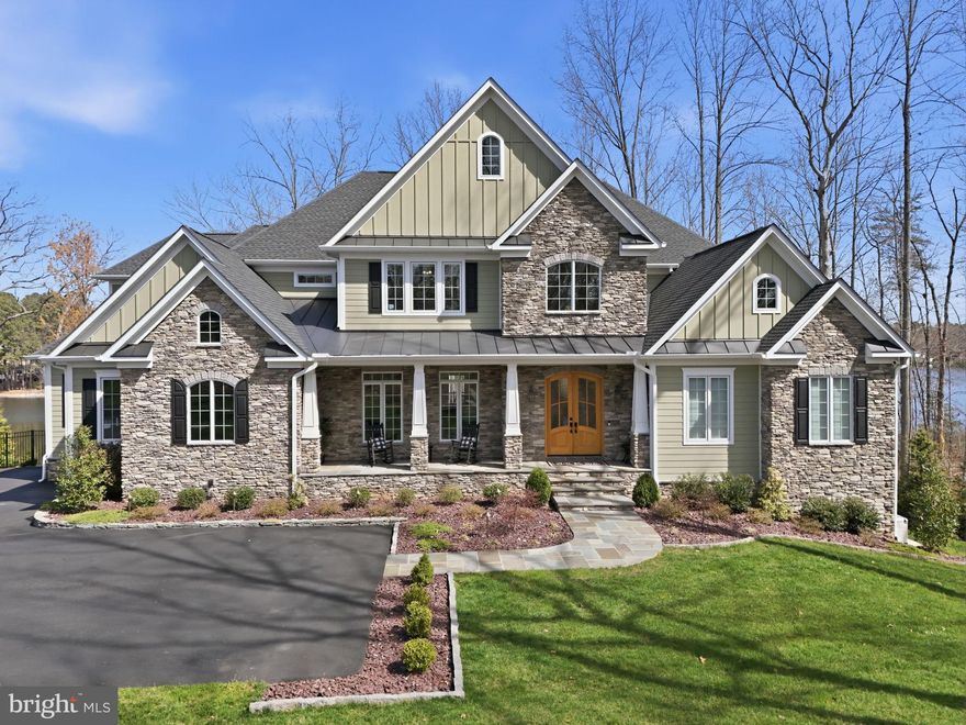 The epitome of waterfront living, this exceptional luxury Dream Home is nestled within Fawn Lake, one of Virginia’s most prestigious gated, resort-style communities.
Meticulously blending Modern Craftsman elegance with timeless architecture, this nearly new masterpiece by Warner Custom Homes offers over 8,200 square feet of exquisitely finished living space across three levels. Perched on a beautifully landscaped 1.50 acre peninsula lot with 367 feet of shoreline, the residence captures breathtaking panoramic water views while offering privacy, tranquility, and natural beauty. 
Designed to embrace the full allure of waterfront living, the remarkable Home showcases an effortless flow of light-filled spaces oriented to maximize the stunning lake views, creating an atmosphere where refined elegance and everyday comfort exist in perfect harmony. 
The thoughtfully designed floor plan balances expansive gathering spaces with intimate retreats, all enhanced by high-end upgrades and custom finishes throughout.
A soaring two-story foyer, anchored by a grand staircase with iron balusters, creates a striking first impression. Beyond, the spectacular Great Room features a dramatic wall of windows framing sweeping lake views, a two-story tongue-and-groove Coffered Ceiling, and a stunning limestone fireplace flanked by custom built-in media cabinetry.
The showstopping gourmet Chef’s Kitchen is beautifully appointed with custom cabinetry, granite countertops, a massive center island, and top-tier appliances, including a Wolf six-burner cooktop and separate Thermador refrigerator and freezer. Designed to accommodate both everyday living and grand-scale entertaining with ease.
Adjacent to the kitchen, a sunlit breakfast area with expansive windows offers captivating water views and seamless access to the oversized deck, perfect for seamless indoor-outdoor lakeside living.
The gorgeous formal Dining Room provides an elegant setting for entertaining, while a bright, inviting Morning Room with a wall of windows offers a  versatile space to relax and unwind.
The main-level Primary Suite is a true sanctuary, featuring a private sitting area with serene water views and a luxurious spa-inspired bath complete with a walk-in Roman shower, soaking tub, dual vanities, custom cabinetry, and an expansive walk-in closet with built-in organization and a dedicated dressing vanity.
Upstairs, a dramatic overlook captures sweeping lake views and leads to a second Owner’s Suite, along with two generously sized bedrooms with ensuite baths, each thoughtfully designed for comfort, privacy, and style. The open loft with a built in media center is perfect for movie nights. 
A spacious loft with a built-in media center provides the perfect setting for movie nights or casual gatherings.
The walkout lower level is equally impressive, offering exceptional space for entertainment and leisure. Highlights include a large recreation room with a custom wet bar and stone fireplace, a fully equipped gym, a home office, and an additional Bedroom suite with a full bath. A wall of glass doors opens to the outdoors, enhancing the home’s seamless indoor-outdoor lifestyle.
Outdoor living is just as extraordinary, with an expansive deck off the kitchen, a covered porch, and a flagstone patio below, each offering idyllic spaces to relax and entertain while taking in the lake views. The park-like grounds feature a stone pathway leading to the water’s edge and a private dock, providing direct access to boating, fishing, and paddleboarding.
The waterfront setting with ever-changing views and a calming ambiance, provides a perfect backdrop for creating lasting memories. Whether entertaining on a grand scale or enjoying quiet, everyday moments, this extraordinary residence offers an incredible opportunity to embrace the magic of Country Club life and the ultimate waterfront lifestyle in the prestigious and vibrant golf Community of Fawn Lake!