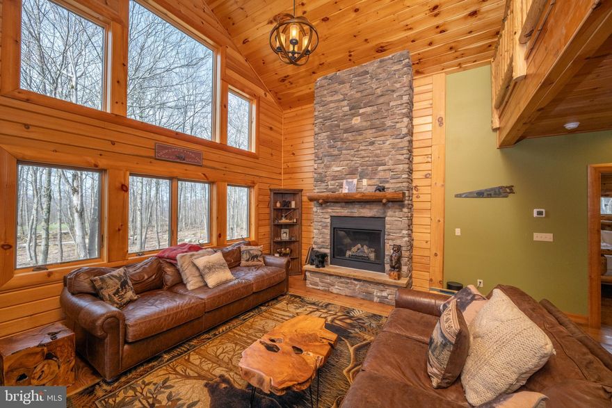 276 Sundance Way – a 3BR, 3.5BA Mountaineer Log Home built in 2018, set along Hole 6 of Lodestone Golf Course with a private, wooded backyard. The main level features an open kitchen, dining, and living area centered around a large island, along with a primary bedroom, laundry room, and half bath off the entry. Upstairs offers a large loft, two spacious bedrooms, and a full bathroom, giving guests their own space. The lower level is fully finished with a second living area, full bathroom, storage, a vault-style safe, and access to the garage. Outdoor living includes a wraparound porch with multiple seating areas and a private deck off the primary bedroom—easy spots to unwind and take in the setting. Located near a ski access trail and walking paths throughout the community. Just minutes to Wisp Resort, Deep Creek Lake, and year-round recreation. Lovingly used by single families that have never rented, the home has been well cared for. Short-term rentals are permitted, offering flexibility if desired.