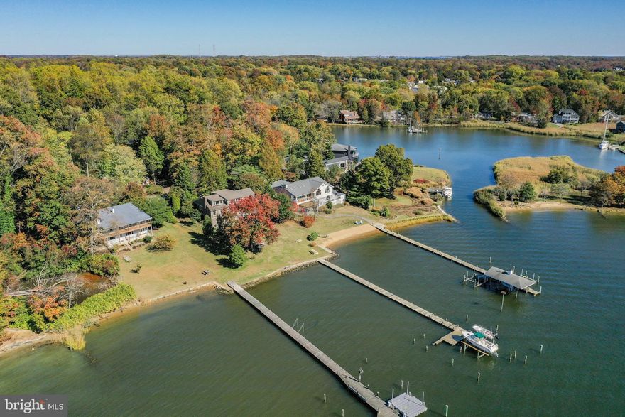 BACK ON THE MARKET!  Unsurpassed views of the South River with a quick boat ride to the Chesapeake Bay. Your own sandy beach. Covered boat slip which is no longer available. 3 additional slips make this exciting property your own private playground. Located at the end of a cul-de-sac, This custom home is surrounded by extensive hardscape with Belgian stone edging. A welcoming 6 ft wide walkway of Pennsylvania blue stone slate leads you to a large covered front porch with blue stone slate floor & a cedar ceiling. Huge covered back porch/deck with mahogany wood floor & cedar ceiling is easily converted to a screened in porch or garden room. Nautical stainless steel cable railings give this home that special coastal feeling. Bluestone slate also on walk ways to pier and waterside porch. Huge pergola covers the stone patio with mosaic insert. Enter through a limestone foyer. Be wowed by the stunning views out massive windows.Cedar ceilings in the main rooms. See all the way across the South River to Selby Bay and Turkey Point. Open floor plan features a library/music room separated from the great room by large columns. Built in display shelves with special lighting and a stone(gas) fireplace with large re-claimed wood mantle adds to the ambiance of this picturesque interior. Additionally there are hardwood floors. The gourmet kitchen also showcases the incredible view and backyard family playground from the huge palladium window. Ceramic floor, Mexican tile, natural solid cherry cabinets,(tongue & groove) extra large island for food prep and entertaining make this a real cook's kitchen. Main level master with additional Palladium window brings the outside in. An outside exit on the side brings another spot to have your morning coffee. Two additional bedrooms on the main level, and one of two laundry rooms---the other one is in the lower level to accommodate the 2 bedrooms and full bath with outside entrance so your guests can come in from sun and fun and shower without walking through the home.There is an outside shower as well. The huge family room with outside entrance also features the VIEW and second stone fireplace with extra large mantle of reclaimed wood. 12 ceiling fans.  Tankless hot water heater replaced 2016. 2 A/C units, replaced in 2015 and 2016. NEST programmable thermostats. Roof and gutters replaced last 6 years. New well pump & automatic water filter 2019. Water conditioning system replaced 2013. Brand new front rails and entry steps. This property is in a NON MANDATORY HOA. But there is a beach, pool and marina if new owner wants to join