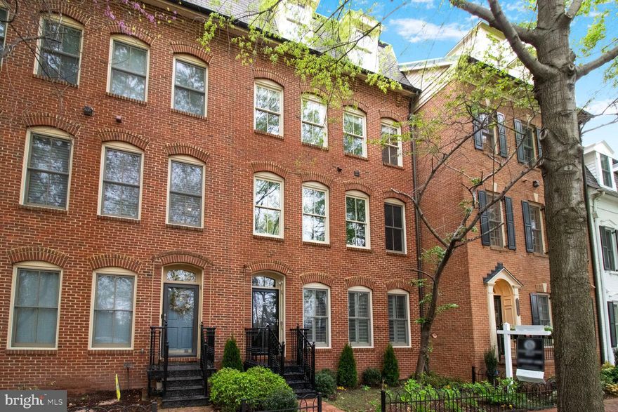 Tucked within the heart of the esteemed Potomac Green community lies one of its grandest residences—an architectural gem rarely seen on the market. This elegant four-level Colonial home, bathed in natural light and thoughtfully crafted across 3,700 square feet, weaves comfort, sophistication, and functionality into a seamless tapestry. Designed for modern living, its generous floor plan gracefully accommodates the rhythm of daily life, blending the needs of remote work, refined relaxation, and gracious entertaining. With four bedrooms, three and a half baths, a dedicated home office, a stately library, and a sweeping grand room adorned with bespoke enhancements, the home invites both admiration and ease.
Every corner reflects meticulous attention to detail—from the custom-built bookcases in the library and grand room to the graceful interplay of crown molding and wainscoting, which lend a sense of timeless grandeur to the interiors. The journey begins at the main entry, where the library greets with a quiet dignity, a versatile space that may serve as a fifth bedroom, complete with its own full bath. As you ascend into the heart of the home, the main level unfurls with an effortless elegance, revealing a soaring grand room with ten-foot ceilings, a gourmet kitchen gleaming with high-end Viking appliances, a refined dining room, and a sunlit balcony outfitted with a natural gas grill—perfect for evenings spent under open skies.
The third level offers a sanctuary in the form of the owner's suite, a tranquil retreat adorned with custom closets, tailored window treatments, and a hand-crafted area rug that anchors the space in warmth. Here, two additional bedrooms, drenched in natural light and graced with verdant views, share another full bath, while a cleverly designed laundry room—complete with built-in cabinetry—adds a touch of everyday comfort.
Crowning the residence is a top-floor haven, conceived as a private guest suite or an inspired home office retreat. This level boasts a spacious bedroom, walk-in closet, full bath, and a separate living area that opens to an expansive rooftop deck. Framed by floor-to-ceiling windows, the space offers an exquisite venue for alfresco dining, enhanced by a gas grill hookup. Fresh paint throughout the interior and exterior, along with a new dual-zone HVAC system, ensures the home is as well-maintained as it is beautiful.
Beyond its walls, the community itself echoes the charm of a storybook village, with a clubhouse, gym, swimming pool, party room, and ample green spaces dotted with tot lots and walking paths. Pocket parks and fiber-optic connectivity from Verizon enrich the living experience, while the tree-lined streets and brick sidewalks recall the timeless elegance of Old Town Alexandria. The home’s location is unparalleled-steps from the Potomac Yard Metro Station and a short stroll to Potomac Yard Center, close to the new Virginia Tech Innovation Campus, and just minutes from the cultural heartbeat of Old Town, Reagan National Airport, Amazon’s HQ2, and downtown Washington, D.C. With biking trails that stretch from Mount Vernon to the capital, every commute or escape becomes an experience. This is more than a home—it is a lifestyle, a rare opportunity to dwell in style and convenience.