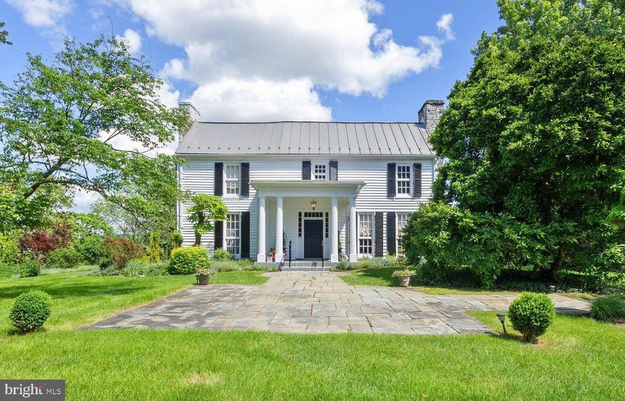 Welcome to The Hermitage, a historic gem of Jefferson County. Set on 5.25 acres and nestled at the end of a long, tree-lined drive, this enchanting residence boasts Provençal gardens, mature landscaping, and sweeping vistas of the Blue Ridge Mountains, providing unparalleled privacy and sophistication. The Hermitage stands as a testament to local history, once owned by local figures such as the Hite family, Daniel Burnett, and Roger Preston Chew. Its grounds feature an early 18th-century main residence, the original 18th-century stone cottage, a 2-car garage, swimming pool, and tennis court. The stone cottage, a rare 1-1/2 story Georgian of limestone construction dating back to c. 1734, is arguably the oldest structure in West Virginia and a cherished relic of Jefferson County's heritage. The heated pool, surrounded by lush shrubbery and fragrant roses, offers a tranquil retreat on hot summer days, while a pathway leads from the pool to the tennis court, inviting leisurely games under the sun. Throughout the property, expansive hardscaping, multi-level patios, and screened-in porches create idyllic spaces for relaxation and entertainment. The main house captivates with its turn-of-the-century center portico, 3 foot limestone foundation, gable-end chimneys, and newly installed standing seam metal roof. Inside, the foyer welcomes with yellow pine floors, a walnut handrail, and tongue-and-groove wainscoting. The formal living room, adorned with a fireplace and floor-to-ceiling double hung windows, bathes in natural light, while a cozy den exudes warmth with its rich wood paneling and brick fireplace. A spacious dining room, adjacent to the den, spans the width of this wing and is ready to host gatherings with loved ones, while an enclosed screened porch offers a serene escape to the backyard. Just off of the dining room is a convenient full bathroom, adding functionality to the main level. Continuing through the dining room, the kitchen stands within the perimeters of the original 18th century cookhouse. This area features a wood cabinets, exposed beams, and pantry/laundry area. A second screened porch off the kitchen invites al fresco dining overlooking the gardens and stone cottage. Upstairs, three bedrooms await with raised ceilings, wood flooring, and recently restored plaster walls. A renovated oversized full bath crowns the upper level, blending convenience with luxury. This remarkable property is more than a home; it's a living testament to a bygone era. From its resorted and preserved architecture to its storied past, this estate offers a rare opportunity to own a piece of timeless elegance. 24 hours notice required for showings.