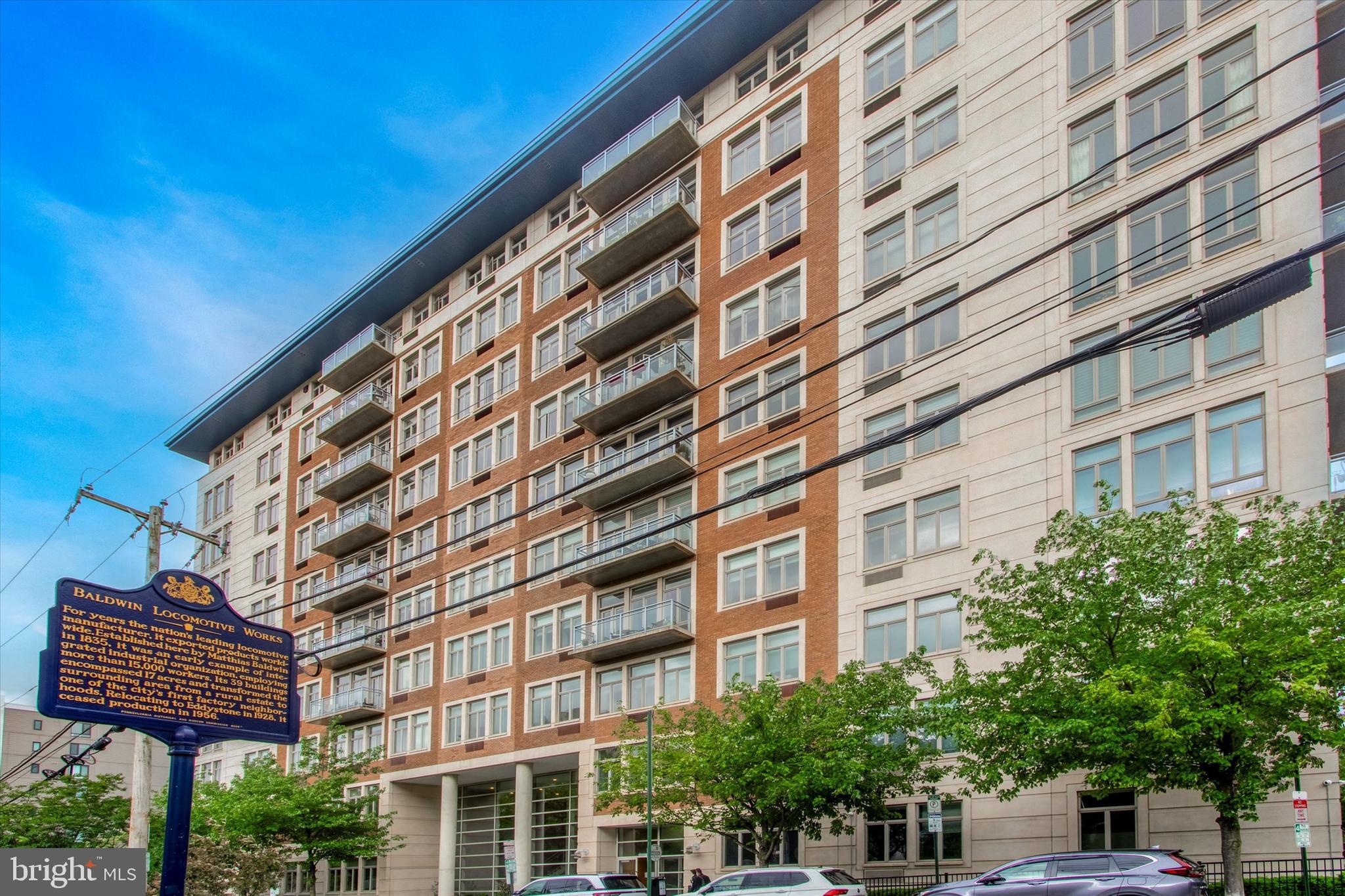 Welcome to 1900 Hamilton Street, home to The Tivoli Condominium Building. This sought-after residence offers the added benefit of 1-car garage parking and sits adjacent to Matthias Baldwin Park. Upon entry, you'll be welcomed by a 24/7 doorperson and a spacious lobby adorned with modern accents. A quick elevator ride to the fourth floor leads you to unit #402, situated on the Southern side of the building, offering captivating city views and abundant natural light. Stepping into the condo, you'll find hardwood flooring throughout, alongside a large coat closet and a convenient laundry closet in the foyer. The open kitchen boasts ample counter and cabinet space, a gas range, and pantry storage. The combined Living Room/Dining Room, with its lofty ceilings and floor-to-ceiling windows, grants access to a private balcony bathed in southern sunlight. Flanking either side of this living space are two generously sized Bedrooms, each flooded with natural light. The Primary Bedroom features a walk-in closet and an En-Suite Bathroom with a shower/tub, while the second Bedroom, also equipped with a walk-in closet, enjoys access to the Full Hall Bathroom. The Tivoli Building offers residents access to a top-tier fitness center, a children's playroom, a meticulously maintained grass courtyard with a serene fountain, and a community lounge complete with a pool table, catering kitchen, and private conference room. With its close proximity to Whole Foods, Target, Kite & Key, the Central Library, and Kelly Drive, convenience abounds in this vibrant locale!
