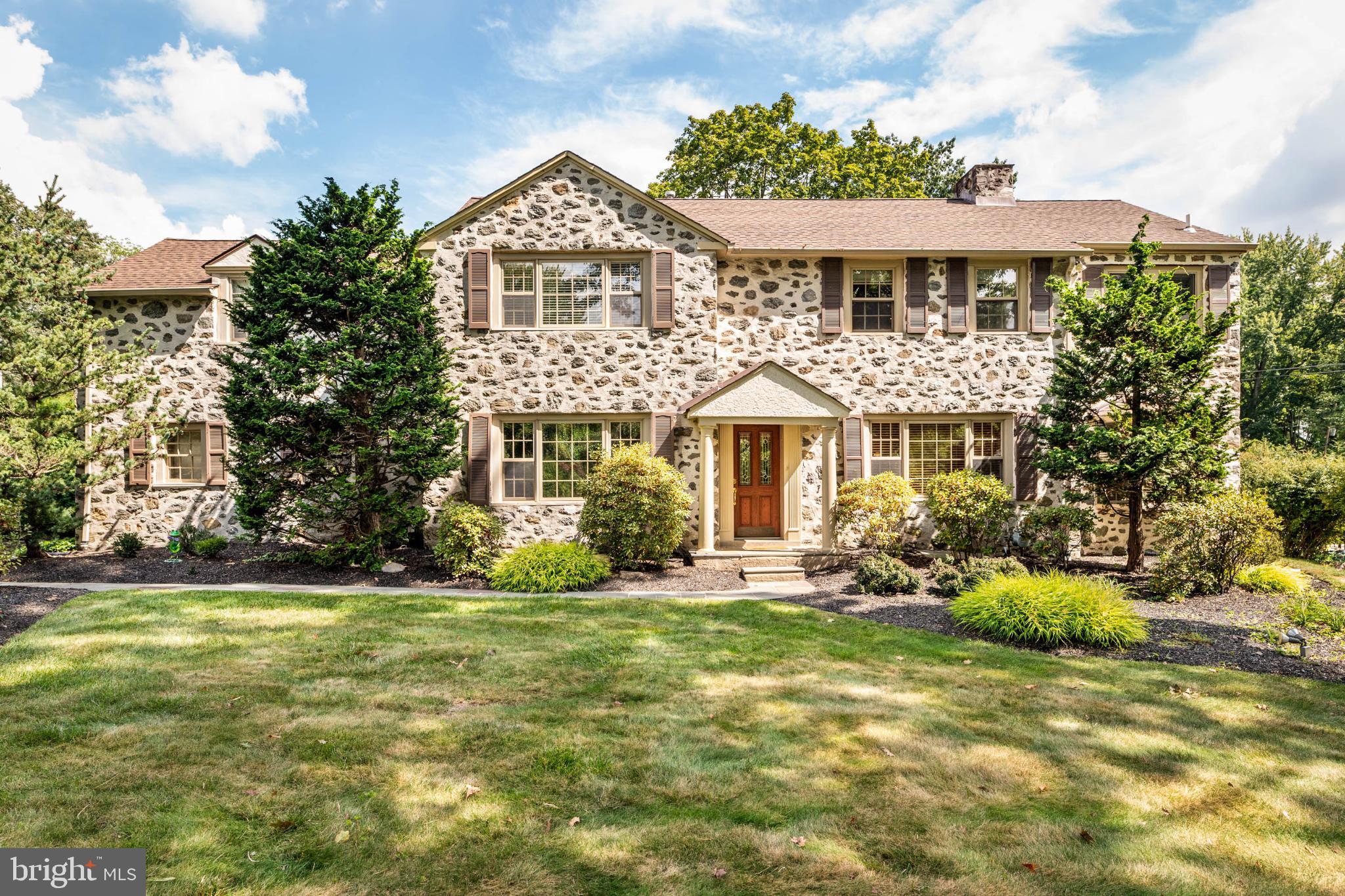 Welcome to your dream home in the heart of Penn Valley, where timeless Main Line charm meets modern, turnkey living. Set on a beautifully manicured, flat backyard oasis, this meticulously maintained 4-bedroom, 3.5-bath colonial invites with stunning curb appeal, anchored by lush professional landscaping and an iconic Japanese maple. Step inside the elegant fieldstone-front entryway and discover sun-drenched spaces with original oak hardwoods, deep-silled windows, and a seamless floor plan designed for effortless entertaining and comfortable everyday living. The versatile living room features a classic, decorative fireplace and custom built-ins, flowing directly into a spacious, beamed family room with skylights and a cozy gas fireplace. French doors throughout the main level create an inviting indoor-outdoor connection, opening to a lovely brick patio and a rare, level backyard, ideal for play, parties, and outdoor upgrades. At the heart of the home, the stylish modern kitchen (boasting cherry cabinetry, granite counters, and GE Profile appliances) connects with a sunny breakfast room and abundant storage. Host memorable dinners in the gracious formal dining room, or work from home in the light-filled office with easy outdoor access. Upstairs offers a generous landing with convenient laundry, and a primary suite with two walk-in closets and a spa-inspired bathroom featuring soaring ceilings, a Palladian window, double vanities, and a luxurious walk-in steam shower. Three additional bedrooms, including a guest or au pair suite with dedicated stairs and an en suite bath, offer flexible living options for every need. A finished lower-level provides bonus flex space, perfect for playroom, gym, or media lounge, plus plenty of storage. Enjoy true convenience with an attached 2-car garage, extra parking, and a mudroom for all-weather access. Served by top-rated Lower Merion schools within walking distance, this move-in ready home combines prestige with the convenience of easy access to shopping, dining, and a Center City commute. Unlock the Main Line's premier lifestyle. Schedule your showing today before this rare opportunity disappears.