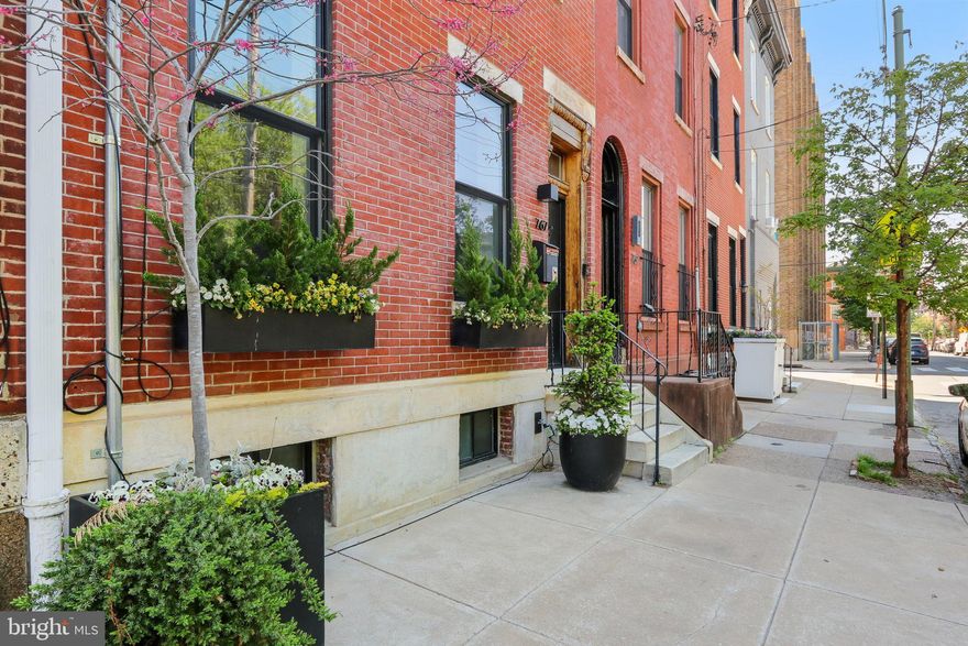 Nestled in the highly sought-after and desirable neighborhood of Hawthorne, this luxurious 3-story rowhome with a detached 2-car garage and separate apartment offers endless upgrades and two years remaining on the tax abatement. No expense has been spared to completely renovate this iconic home that is situated directly across the street from the tranquil Hawthorne Park. This home exudes authenticity from the curb. Upon entering, you're greeted by 10' ceilings, a stunning brick wall and a living room/office with glass French doors and a cozy wood-burning stove. The main level also features an extraordinary mudroom with custom woodwork, including built-in cubbies, closets, and shoe racks, along with a full hall bathroom and a back bedroom that serves perfectly as a guest suite. This room leads out to a huge private garden oasis. The second level featuring the showstopping all-white kitchen is a chef's dream, boasting an oversized island, custom Poggenpohl cabinets, a 43" La Cornue dual oven, Subzero Fridge, and high-end lighting fixtures and finishes. The adjacent dining room offers ample space for a table of 8 or more, while French doors lead to a cozy sunroom with a built-in BBQ grill, perfect for year-round entertaining. The grand family room is anchored by an exposed brick wall, accent built-ins, indoor swing, and a gas fireplace, creating a warm and inviting space for all. On the third level, the primary bedroom continues the theme of luxury with its own exposed brick wall, 18' vaulted ceiling, separate HVAC system, walk-in closet, and an ensuite bathroom featuring heated floors and an instant hot seamless shower. Two additional well-sized bedrooms with walk-in closets share a beautifully designed full bathroom with another seamless shower and separate soaking tub, laundry chute and heated flooring. Ascend to the rooftop terrace, where you're greeted by a rare sight, a residential green roof which creates an idyllic oasis, complete with a covered pergola for sun and rain protection, a sitting area with a gas fireplace, a wet bar with a fridge, and a weather proof Samsung "The Terrace" TV, all surrounded by panoramic city views for relaxation. Sunrises and sunsets can be seen throughout every window in the house; however, they are exceptionally stunning on the roof garden spaces. The fully finished basement is a true standout, featuring extra-high ceilings, radiant hot water flooring, and a laundry room with a convenient laundry chute. The kitchenette, complete with cabinets, a sink, and a fridge, is ideal for multi-functional use, while the massive storage area, exercise room, and a 700-bottle wine cellar provide ultimate comfort and versatility. Continue out the back door to a private patio with professional landscaping, including landscape lighting, a drip irrigation system, and a fountain, all leading to a detached 2-car garage, ensuring parking is never an issue. Above the garage is a 400-square-foot one-bedroom apartment, perfect as an au pair suite, guest quarters or as a fully permitted rental property. This apartment features its own kitchen, washer/dryer combo, full bathroom with a seamless shower, and ample living space. It is a truly unique space as special as the main home and shares no walls with any other building! Additional luxury features throughout the home include 1840’s-1850’s Cherry hardwood flooring throughout. The smart home elements include Lutron lighting with automation, professional Wi-Fi routers on all levels, Cat 5 connections in every room, a whole home speaker system with mobile app connect, and a full security camera system. Located away from the hustle and bustle of the city yet just blocks from every major area that Philadelphia has to offer. Not to mention only blocks from the Italian Market and 5 grocery stores for convenience. This home is the perfect blend of tranquility and urban luxury -- if you want to live in a truly unique, and special home, this is the one!