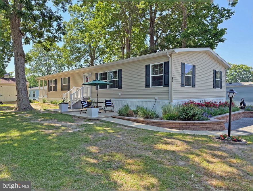 This spacious house, with pretty landscaping, is just a few doors away from the community pool, and it is only 3 miles from the Rehoboth boardwalk and beaches. With four bedrooms and 1,624 sq. ft. of living space, this could be your ideal permanent residence or an elegant beach get-away. The living room, with an electric fireplace, opens to the nicely-appointed kitchen. The kitchen features a tile backsplace and a center island for more prep space. The crisp black appliance package includes a fridge with ice maker, a smooth-top electric range, built-in microwave, and a dishwasher. The kitchen adjoins the dining area, which has a buffet/sideboard area with extra counter space and cabinetry. The laundry area is next to the kitchen and it has a full-size side-by-side washer and dryer. The family room is at the rear of the house. The French door lead out to the expansive covered porch. The family room also has an electric fireplace. The main bedroom is en Suite with a walk-in shower, double-sink vanity, and a linen closet. The second full bath has a tub shower, and is located near bedrooms #2 & #3. The fourth bedroom is at the rear of the home, so it feels like a mini suite because it adjoins the family room. Lennox electric forced air heat, central AC & ceiling fans.  Cute cottage-style outdoor storage shed. Silver View Farm is close to the beaches, shopping, & restaurants. The DART Bus Park-n-Ride is just down the road if you don’t feel like hunting for parking at the beach. Annually renewable leasehold interest: Lot Rent of $760.71/mt. includes water & trash/recycle service (Lease renews annually on Jan. 1 with any increase capped per law – 25 Del. C. Sec. 7050-7054). Homeowner pays electric, sewer, cable/Internet (Xfinity) & lawn service. Silver View Farm allows 2 pets – no dog breed restriction per a newer DE law. Pool membership is optional (approx. $175/person with discounted group packages). A Park Application ($72/person) is required for all adults who will occupy the home for 14 or more consecutive days. Buyers are accepted as a Resident in Silver View Farm based on the following criteria: 1.)income verification, 2.)high credit bureau score, 3.)evaluation of debt-to-income ratio, and 4.)criminal background check. Note: Rentals are NOT permitted in this community - but friends & family are welcome to visit you. Financing may be available to qualified borrowers from only a very few Lenders that specialize in installment/chattel loans for manufactured homes on leased land. Closing costs will include a 3.75% “real estate transfer tax” (DMV Doc Fee) & a Settlement Agent Fee.