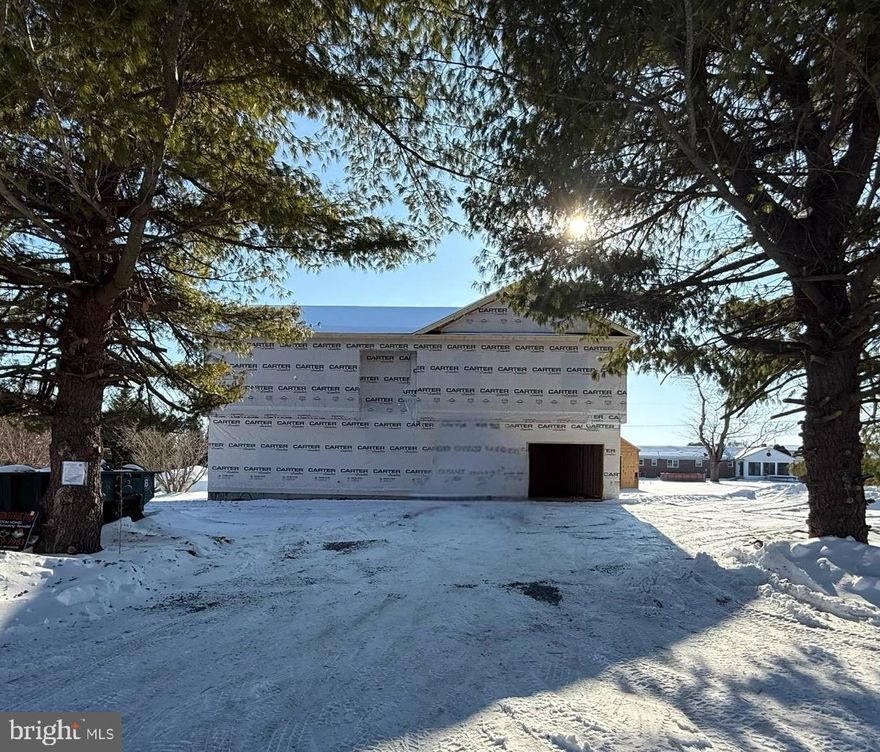 This well-designed new-construction home is currently under construction and will be ready in estimated April. Situated on a level lot with mature trees in Orchard View Estates, this home features 4 bedrooms and 3 full bathrooms with a functional and spacious layout. The exterior showcases vinyl siding with stone accents, recessed exterior lighting to accent the home, nicely paved new driveway, and a welcoming front entry with white vinyl railing and steps.Inside, luxury vinyl plank flooring runs throughout the home, including vaulted ceiling areas, enhancing the open and airy feel. Abundant windows throughout provide excellent natural light. The kitchen features white cabinetry with black accent hardware, a center island, a built-in pull-out pantry, and stainless-steel appliances.The primary suite offers a shiplap accent wall, with matching shiplap detailing in the primary bathroom behind the vanity. The ensuite bathroom includes a stand-alone soaking tub, a tiled shower, and black-accent mirrors and fixtures.The finished walk-out basement features 9-foot ceilings, a generous-sized bedroom, a large living or flex space, washer and dryer hookups, and exterior access through a 6-foot sliding door. Additional features include a 12x12 rear deck (no steps; steps available at an upgraded cost), an oversized 24x28 attached two-car garage, and a detached 17x24 one-car garage with electric and loft storage.Located in Orchard View Estates, the property offers a prime location with close proximity to the VA Medical Center,  Procter & Gamble, Amazon, and convenient commuter routes to Virginia, Maryland, and Washington, D.C.A quality new-construction opportunity in a highly desirable and convenient location.