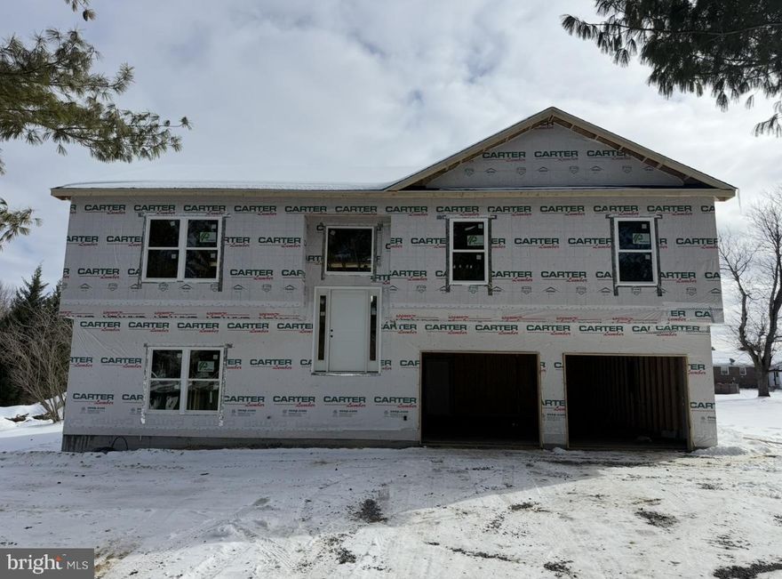 This well-designed new-construction home is currently under construction and will be ready in estimated April. Situated on a level lot with mature trees in Orchard View Estates, this home features 4 bedrooms and 3 full bathrooms with a functional and spacious layout. The exterior showcases vinyl siding with stone accents, recessed exterior lighting to accent the home, nicely paved new driveway, and a welcoming front entry with white vinyl railing and steps.Inside, luxury vinyl plank flooring runs throughout the home, including vaulted ceiling areas, enhancing the open and airy feel. Abundant windows throughout provide excellent natural light. The kitchen features white cabinetry with black accent hardware, a center island, a built-in pull-out pantry, and stainless-steel appliances.The primary suite offers a shiplap accent wall, with matching shiplap detailing in the primary bathroom behind the vanity. The ensuite bathroom includes a stand-alone soaking tub, a tiled shower, and black-accent mirrors and fixtures.The finished walk-out basement features 9-foot ceilings, a generous-sized bedroom, a large living or flex space, washer and dryer hookups, and exterior access through a 6-foot sliding door. Additional features include a 12x12 rear deck (no steps; steps available at an upgraded cost), an oversized 24x28 attached two-car garage, and a detached 17x24 one-car garage with electric and loft storage.Located in Orchard View Estates, the property offers a prime location with close proximity to the VA Medical Center,  Procter & Gamble, Amazon, and convenient commuter routes to Virginia, Maryland, and Washington, D.C.A quality new-construction opportunity in a highly desirable and convenient location.