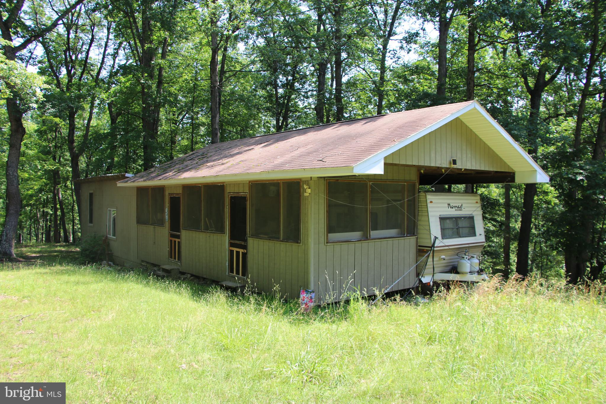 Own a piece of the beautiful Siler Heights community in Cross Junction. Located just minutes northwest of Winchester near Lake Holiday. Access is secured via extensive road frontage on Easter Ridge Lane. Features a fully functional hunting cabin wired for a generator hook up with propane used for heating and cooking. The cabin has an open layout and separate sleeping quarters in an attached camper. Experience exciting hunting as many types of wildlife call this property home including deer, turkey, and many small game species. There are potential building sites located throughout the property. This tract is currently being used for recreation but it would also make an excellent site for your dream home or vacation rental. An expired 3 bedroom septic permit is on record with the county health department. Stellar views of the surrounding countryside are attainable with some tree clearing. This property features mildly sloping topography which is builder friendly and allows for enjoyment of the land. Currently enrolled in the county’s forestry land use program to reduce the annual taxes. This is a fully wooded property that is zoned Rural Areas (RA). Enjoy hiking, camping, and recreation of all types on this land. A short drive from all the amenities and attractions Winchester has to offer.
***Additional adjoining acreage available for purchase. See aerials for details.***
***The land and cabin are being sold in AS-IS condition.***