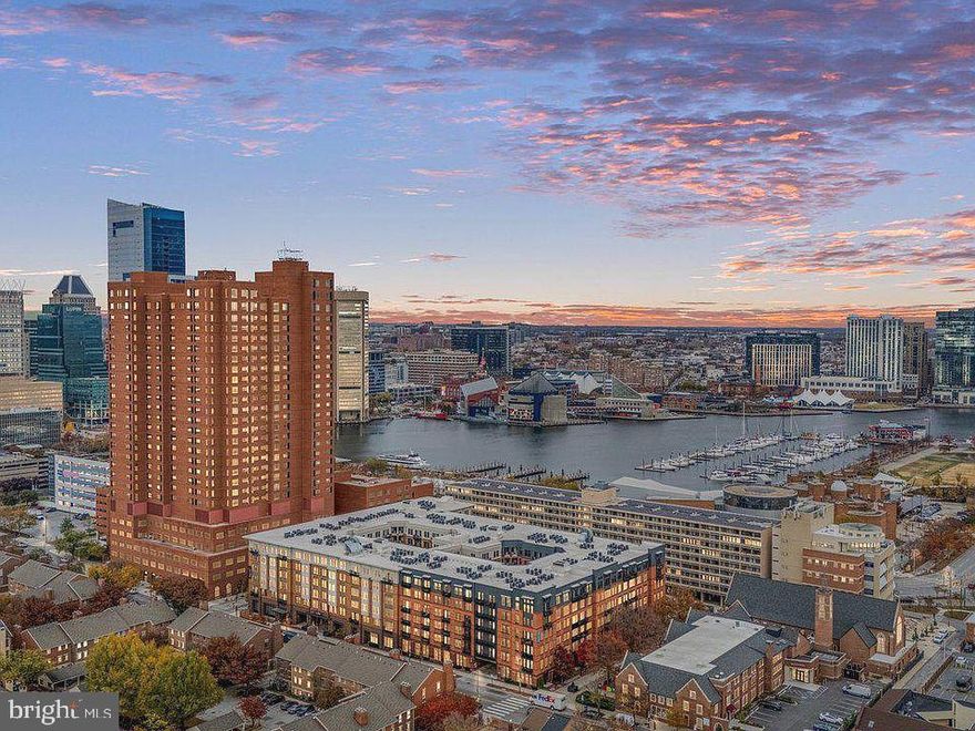 REDUCED! Welcome to The Towers at Harbor Court- a coveted luxury hi-rise condominium located in Baltimore's vibrant Downtown/Inner Harbor area.  This rarely available  3-bedroom + den, 2.5-bathroom model offers over 2,100 square feet of living space, with expansive rooms and spectacular views. Includes new white oak flooring.  The heart of the home is the recently remodeled gourmet kitchen, a chef's delight with quartz countertops,  under-cabinet lighting and top-of-the-line appliances including a Wolf induction stove, Cove dishwasher, and GE Café refrigerator, plus thoughtfully designed extra storage space (with room for a freezer), ample pantry and convenient newer LG washer and dryer.  New electric hot water heater.
The spacious primary bedroom suite features multiple built-ins and a stunning bath with separate tub, oversized shower, dual granite topped vanity and magnificent city views. One bedroom has extensive built-ins for use as an office. Extensive storage and closets throughout other rooms.   An airy and light filled living and dining combination area features ambient modern lighting, new chandelier and floor-to-ceiling windows with views of the harbor, the promenade and Aquarium.  
 Harbor Court offers exceptional service and a wealth of amenities. With 24/7 front desk coverage, a uniformed doorman, porters, security, maintenance staff, secure deeded parking (one space), and additional personal storage, every need is thoughtfully addressed. This stable and prime Inner Harbor location also gives residents access to the adjacent Royal Sonesta Hotel, including optional membership at the fitness center and pool/spa.  For those seeking effortless living in a luxurious, amenity-filled environment, The Towers at Harbor Court is a must-see! Positioned near the Inner Harbor, this residence offers proximity to cultural landmarks, diverse dining, and walkable to sports and entertainment venues.