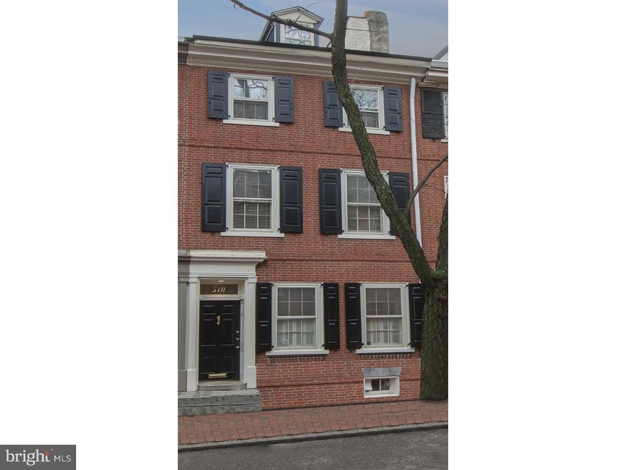 Sunlit, classically styled, 4-5 bedroom brick town home offers exciting, updated interior paired with exceptional original details on its five finished levels on Delancey Street's coveted 500 block. A period 15 paned beveled mullioned glass door opens to the Living Room which is highlighted by dental molding, chair rail and warm, hand nailed, rustic planked floors.  The open floor plan encourages straight forward views through the Dining Room and Kitchen to a full wall of glass and double French doors to a beautiful walled brick terrace enjoying Southern exposure and raised gardens. Spectacular all white Kitchen is highlighted by an oversized prep and seated island with Cashmere granite counters and neutrally selected honed marble subway tiles.  Ascend the center stairs to find the Master Bedroom and recently updated Bath with large seated shower and seamless glass door.  A family Bedroom with hardwood floors and fireplace detailed with arched brick offers two sets of windows along with a second full Bath, renovated with handsome emperor marble. Two additional large Bedrooms with a new Carrera marble bath and full sized Laundry Room are located on the third floor. Brightened by a sky light and south facing window, the fourth floor is ideal space for a large home Office or fifth Bedroom. Fully finished Lower Level with fireplace offers exceptional entertaining or play area, with fireplace, half bath, wine cellar, large storage room with wine chiller and full size overflow refrigerator. An extraordinary offering in move-in condition only steps away to shopping, restaurants, Three Bears Park and historical Washington Square.