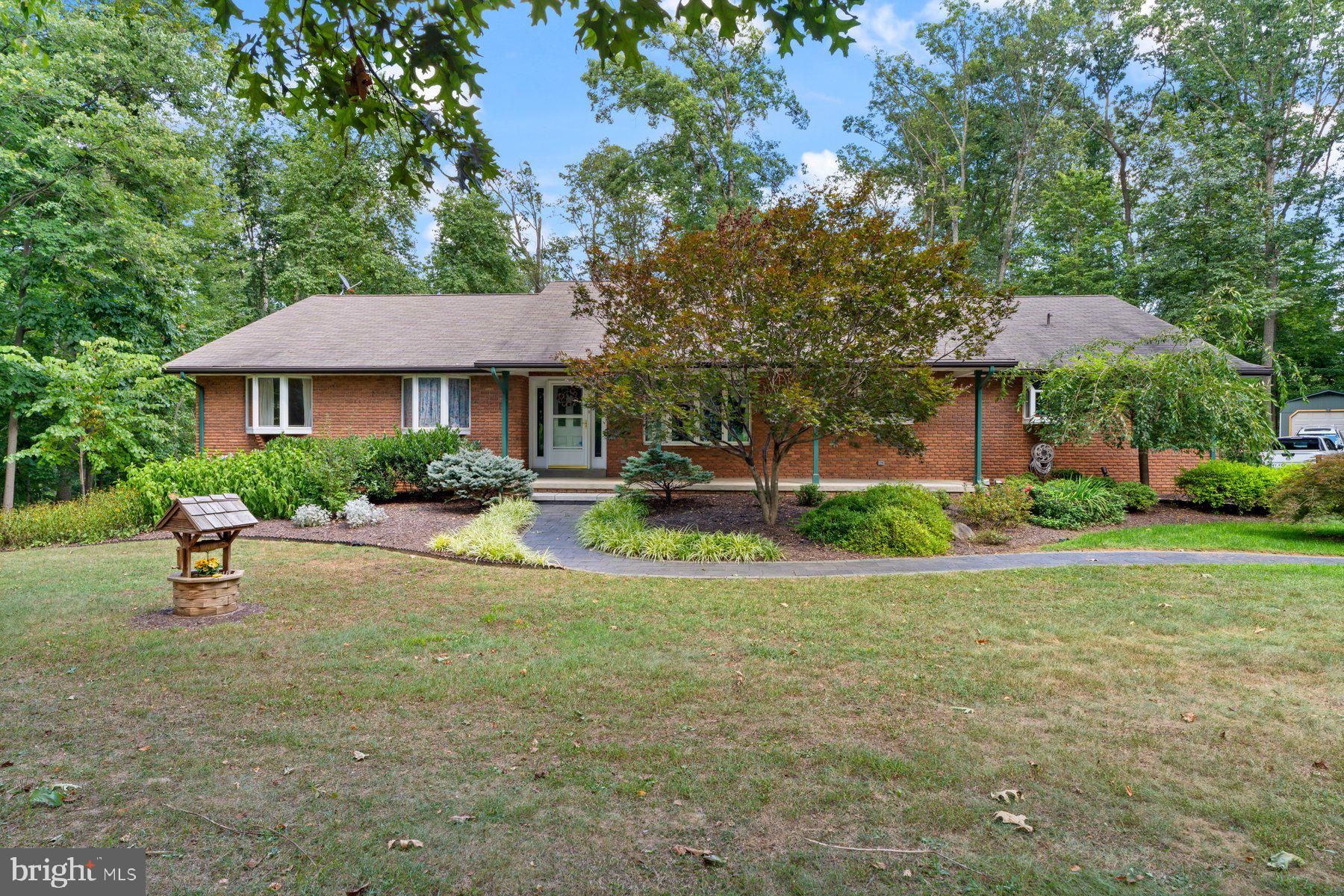 Welcome to 2613 Albert Rill Road, an exceptionally well-maintained and spacious all-brick rancher nestled on a beautifully landscaped lot in Westminster. This home offers 4 bedrooms, 3 full bathrooms and a host of quality upgrades throughout. The main level features new luxury vinyl plank flooring, a personal office, an updated kitchen with 42" cabinets/newer appliances/granite countertops and a cozy living room with a gas fireplace insert. The expansive rear sunroom, accessible from both the living area and the large owner’s suite, provides a peaceful retreat overlooking the backyard. The owner’s suite includes a cedar lined walk-in closet and a fully updated en suite bath with a double vanity and custom shower.
Downstairs, the fully finished walk-out basement offers incredible flexibility, including a large open living area with a wood-burning stove, an optional fifth bedroom, a third full bath with a beautifully tiled shower, and a custom wet bar with a hammered copper sink. New french doors lead to the backyard, perfect for entertaining or relaxing.
Additional highlights include an oversized 2-car attached garage, a detached 1-car garage and two sheds (garage and larger shed have power), providing ample storage and workspace. Systems and mechanicals are in top shape with a new AC and heat pump water heater (2019), energy-efficient 2-zone boiler (oil or wood fired), recently reconditioned water neutralizer and softener, new well pressure tank (2019), and a recently inspected septic system with new risers installed in 2025. The home is equipped with Anderson windows, gutter guards, and a beautiful front porch with custom granite walkway. The large rear paver patio with lighting and expanded parking pad round out this move-in-ready property. A rare combination of space, comfort, and meticulous care—don’t miss your chance to call this property home!