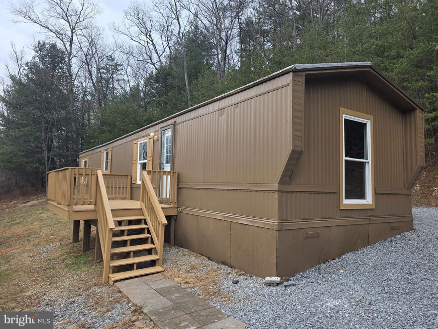 LOT WITH MOBILE HOME: don't miss this 1.76-acre unrestricted property with a Mobile Home, well, septic & electric. This single-wide mobile features 2 bedrooms, 1 bathroom, a kitchen/living room combo and a laundry area. All has been freshly painted and new flooring throughout the entire home. Mobile Home is ready to be lived in, or you can use it as an investment property. Shed conveys with property and has new shingles. This property is on a county road so no need to worry about road maintenance. Property is within 30 minutes of I-81 & Martinsburg, WV.  Don't miss this one, it could make a great starter home or rental.