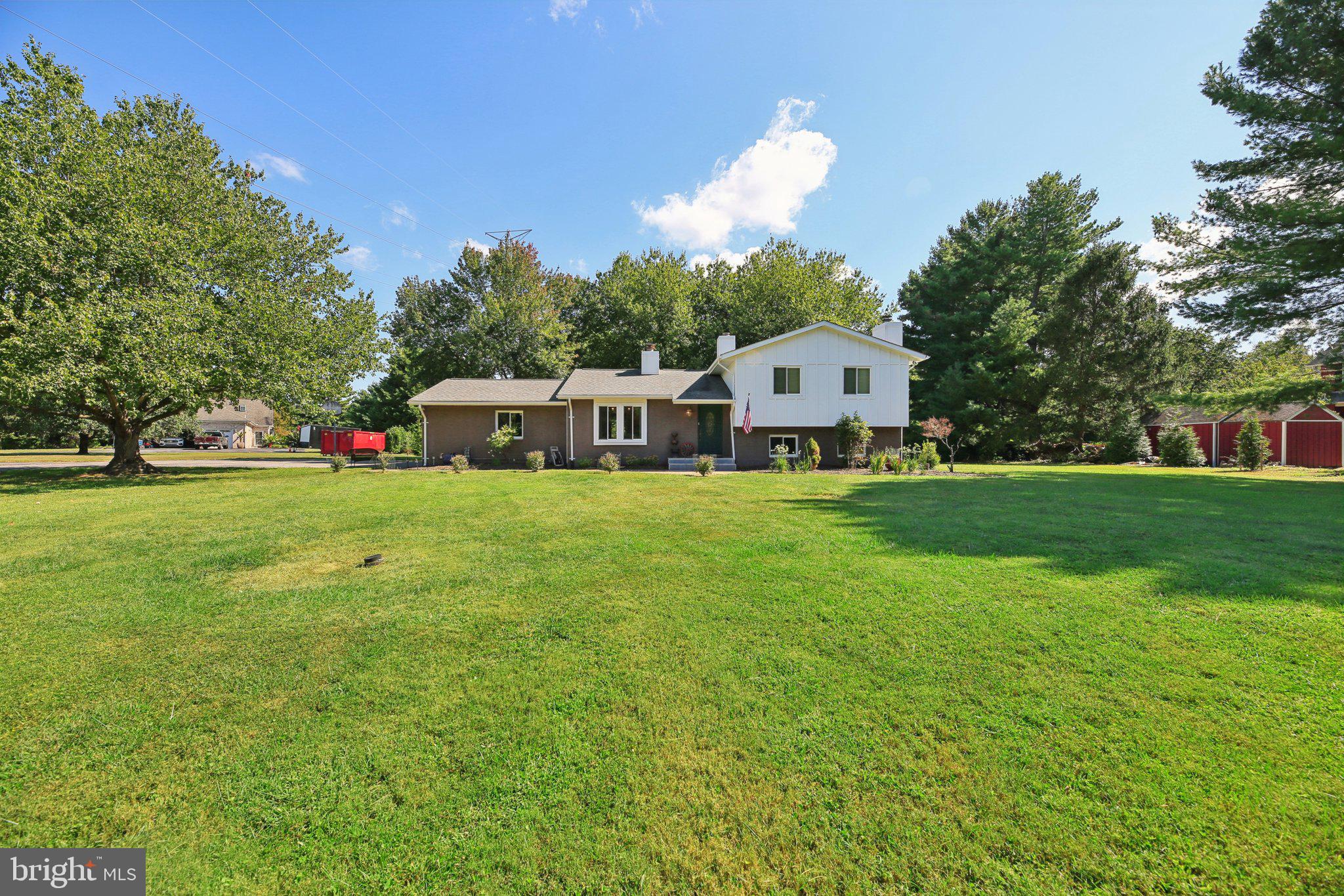 Tucked away on the quiet back roads of Baltimore County, this Timonium gem offers a combination of space, privacy, and convenience. Set on 1.4 serene acres, the property is situated in a serene setting, while still offering quick access to restaurants, shopping, 695, 83, and Baltimore City. The home has been thoughtfully updated over the years, blending modern comfort with timeless charm. The roof was replaced in 2020 with a 50-year architectural shingle (certificate available), and stylish vinyl plank flooring was added in the kitchen and mid-level in 2022, continuing into the lower level which was updated in 2025. The recent lower level renovation includes a new bathroom, custom ceiling, fresh drywall, and upgraded PEX plumbing. Upstairs there is new carpet, an updated primary bath (2025), and a recently installed dishwasher.
Exterior improvements include new board and batten siding (2024) and a custom stone patio with waterfall and fire pit—perfect for enjoying the peaceful setting. The home features an electric water heater installed in 2024 with a lifetime warranty, a gas furnace and A/C system with Nest thermostat (2018), and a whole-house water filter. Additional perks include a two-car garage, ample driveway parking, a garden with raised beds and a greenhouse. This is a true retreat with room to breathe—just minutes from it all.
