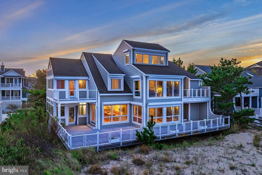 Welcome to this exceptional oceanfront retreat, perfectly positioned within the exclusive gated community of Bayberry Dunes in North Bethany. Offering 75 feet of pristine ocean frontage, this coastal sanctuary captures breathtaking, unobstructed views of the Atlantic Ocean and provides direct access to a private lifeguarded beach. Architecturally designed for gatherings both large and intimate, the residence features five bedrooms, three and a half baths with a spacious additional family room, a built-in bunk bed room, and a private office that could easily serve as a sixth bedroom. Step inside to a sun-drenched great room where windows frame endless ocean vistas and open to an expansive main deck, a perfect setting for entertaining, relaxing, or simply savoring the sound of the waves. The main living area flows seamlessly across terracotta tile flooring, connecting the kitchen, dining area, and family room in a warm inviting layout. The kitchen features custom tile countertops and backsplash, ample cabinetry, and a convenient prep sink for the culinary enthusiast. Large glass doors open to a side enclosed porch, allowing the two dining areas to merge into one continuous space ideal for beachfront entertaining, all leading onto a full-length oceanfront deck. The main level radiates coastal charm with a wood-burning fireplace and two generous bedrooms. Upstairs, the oceanfront primary suite is a private haven, offering its own deck with panoramic ocean views, a luxurious en-suite bath with jacuzzi tub, walk-in tile shower, and bidet. An additional upstairs family room, with circular stairs leading to a cozy loft area, provides even more space for relaxation or recreation. The lower level offers elevated essentials, including covered porch areas, a large storage room for beach accessories, and an outdoor shower, all with direct access to the dune crossover and beach. Set on a large parcel within this private North Bethany community, the home enjoys the security of high elevation and natural dunes, while being just moments from the shops and restaurants of downtown Bethany Beach. Offered fully furnished and move-in ready, this home invites you to experience coastal living at its finest, whether as a cherished personal retreat or a savvy rental investment. Rental investment analysis available upon request. Additional highlights include composite decking, hurricane shutters, oceanfront dining areas, and parking for up to seven vehicles within the driveway and carport. Experience the timeless allure of the Delaware coast, schedule your private tour today and discover the potential of this extraordinary oceanfront property.