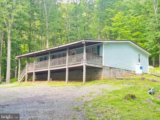 TIRED OF CITY LIVING? ENJOY PLENTY OF ROOM TO ROAM ON THIS 2 ACRE TRACT WHICH INCLUDES A “FULLY FURNISHED” (26’ X 42’) 3 BR, 2 BA RANCHER (D-WIDE) W VINYL SIDING, SHINGLE ROOF, LGE COVERED FRONT PORCH, REAR ENCLOSED PORCH, CONCRETE BLOCK FOUNDATION AND 8-10 GRAVEL PARKING AREA. INTERIOR OFFERS A SPACIOUS LIV RM W CEILING FAN/LIGHT, W-W CARPET & PANEL WALLS. EAT-IN KIT W ALL APPLIANCES, TABLE & CHAIRS, OAK CABS, PANTRY, UTLITY AREA & LINOLEUM FLOORS. 3 BRS WITH W-W CARPETING, DEEP CLOSETS & ATTRACTIVE WALL PANELS. 2 FULL BATHS: (1ST BATH) NEW TUB-SHOWER COMBO, VANITY & VINYL FLOORING. (2ND BATH) GARDEN TUB, SEP ROOM W 6’ VANITY & VINYL FLOORING. HEAT PUMP, ELECT. F/A HEAT, SEPTIC & WELL W/XTROL TANK & (2) AC WINDOW UNITS. OTHER AMENITIES: UNRESTRICTED RAW LAND, DIRECTLY BORDERS STATE LAND (OVER 2000 ACS - MD DEPT OF NATURAL RESOURCES), FULLY WOODED & MARKETABLE TIMBER (RECENT TIMBER EVALUATED BETWEEN $100K-120K IN 2024), TROPHY BUCK HUNTING (INCLUDES CUSTOM BUILT HUNTING BLIND), SHORT DRIVE TO LAKE ACCESS, STONES THROW TO YOUGHIOGHENY RIVER, OVERLOOKS DEEP CREEK LAKE VALLEY.
