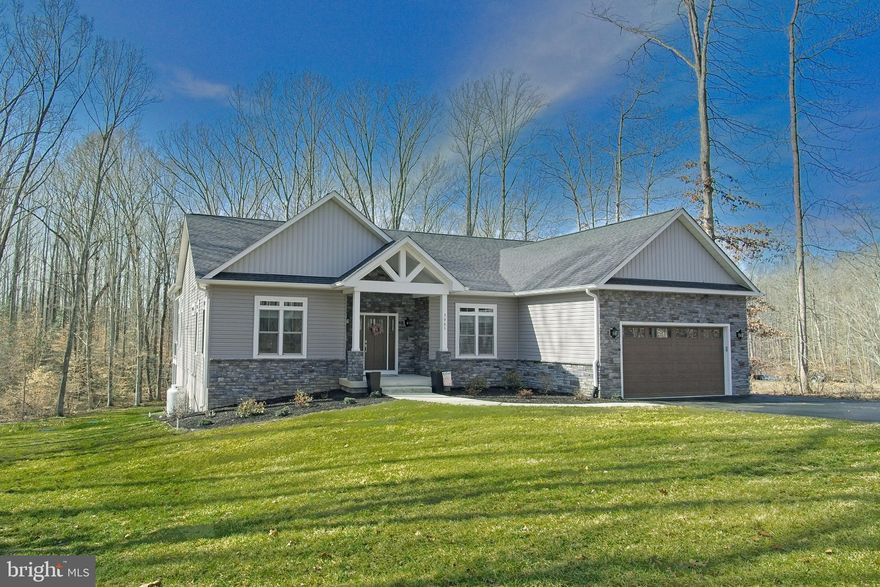 Wake up to your panoramic picturesque vista overlooking the water in this masterfully
designed Lake Anna lakefront sanctuary. Nestled on nearly 2 private acres on a quiet
cul-de-sac location in the desirable Sycamore Shoals neighborhood, this turn-key,
upgraded, 1-year-old custom home offers a private setting with mature trees and your
own waterfront oasis on the south end of Lake Anna on the desirable public side. This
exceptional waterfront home offers roughly 4300 square feet of meticulously designed living
space across two levels featuring 4 bedrooms, 4 full bathrooms (en-suite) and 2 half
bathrooms. As a bonus - The western exposure from the back of the property
overlooking the lake offers breathtaking sunset views.

The property boasts a quiet cove with a private boat dock featuring a screened porch,
sun deck, and covered boat lift making it a haven for relaxation and water activities.
Designed with luxury and comfort in mind, this home offers the ultimate in serene luxury
living featuring on the main level an open flowing layout featuring soaring 14-foot
ceilings with recessed lighting that is flooded with natural light. The expansive open
living area includes a floor to ceiling fireplace, a bar cove with dual beverage coolers,
and sliding doors that overlook the patio, greenery, and lake. The chef’s kitchen
features: quartz countertops, a prep island, tile backsplash, new stainless-steel
appliances, a gas cooktop, dual stoves with convection capabilities, a walk-in pantry,
ample deep-drawer and vertical storage, breakfast bar seating, and a dining area with
sliding doors to the deck overlooking the backyard. The stunning large master suite
on the main level offers panoramic views and custom uplighting, while the spa-inspired
master bath features a double vanity, custom walk-in shower, free-standing tub, and a
large walk-in closet. The 2 car attached garage features generous cabinet and hanging
storage and leads to the laundry/mud room entering the main level. The massive
finished lower level expands the living space even further, offering a large wet bar with
beverage cooler, family room with fireplace, and a recreation area ideal for relaxing or
entertaining. The lower level also features an addition bedroom with en-suite bathroom
and walk-in closet and an additional half bath for the recreation area. This level walks
out through dual sliding doors to a large patio overlooking the parklike backyard and
lake. The lower level also features 900 square feet of unfinished space for storage,
utilities, and workout space. Outdoor living is further enhanced with both a covered and
open elevated rear porch featuring composite decking and stairs, a lakeside stone
firepit, an outdoor shower, and a scenic path to the lake and boathouse. The home
promotes energy efficiency featuring: dual-fuel HVAC system, energy efficient windows
and doors, enhanced insulation, led lighting, electric car charger (rough-in), heat pump
water heaters, and energy efficient appliances.

Whether you’re entertaining guests or seeking a peaceful retreat, this home at 3905
Hatteras Court, Bumpass, VA 23024, provides the perfect balance of luxury, privacy,
and natural beauty. Schedule your private tour today!