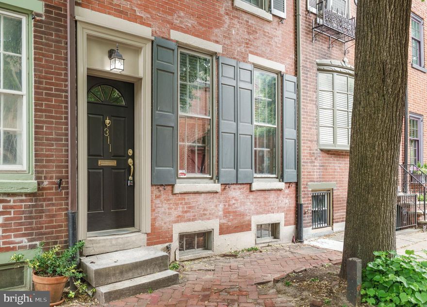 Located on a picturesque, tree-lined block in the heart of Washington Square West, 311 South Camac Street blends timeless Philadelphia charm with thoughtful modern updates in one of Center City’s most sought-after neighborhoods. This spacious three-story residence offers over 1,400 square feet of beautifully maintained living space with 3 bedrooms, 2 full bathrooms, and access to the highly-coveted McCall School Catchment.
Beyond the classic historic façade, the home welcomes you with warm wide-plank hardwood floors, soaring ceilings, oversized windows, and rich architectural character throughout. The inviting living room features custom built-ins and a wood-burning fireplace, creating a cozy yet elegant setting for everyday living. Just beyond, the formal dining room flows seamlessly into a generous chef’s kitchen outfitted with cherry cabinetry, granite countertops, abundant storage, and stainless steel appliances, perfect for entertaining or casual weeknight meals.
The second floor offers exceptional flexibility with a spacious bedroom and an additional open area ideal for a home office, den, or reading lounge. A beautifully renovated full bathroom showcases marble and limestone finishes, a large walk-in shower, and a dedicated laundry area for added convenience.
Upstairs, the top level includes two bright and spacious bedrooms separated by another full bath. The rear bedroom serves as a peaceful retreat with skylight details and direct access to a private deck, perfect for morning coffee or relaxing evenings above the city. Exposed beams, original flooring, and historic details throughout the home create a rare combination of warmth and authenticity.
The lower level provides valuable bonus space ideal for a gym, studio, storage, or additional workspace.
Perfectly positioned just steps from Midtown Village dining, Avenue of the Arts, Antique Row, Jefferson and Pennsylvania Hospitals, and both Washington and Rittenhouse Squares, this home offers an unmatched urban lifestyle. Historic charm, generous living space, and an unbeatable location come together at 311 South Camac Street, an exceptional opportunity in the center of it all.