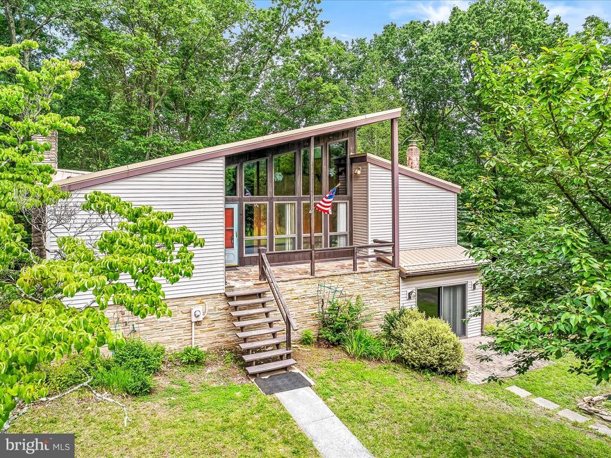 Come and admire this unique home situated on 22 secluded acres consisting of fields and woods.  Home is contemporary in design and offers a ton of potential.  Lots of natural light from all of the windows.  Features a wood stove and a fireplace also.  Wooden accent beams upstairs really set off the look.  A large detached garage for parking and storage.  Full finished basement for extra living space and storage.  Stone accent walls surround the bottom portion of the home as well.  A must see!