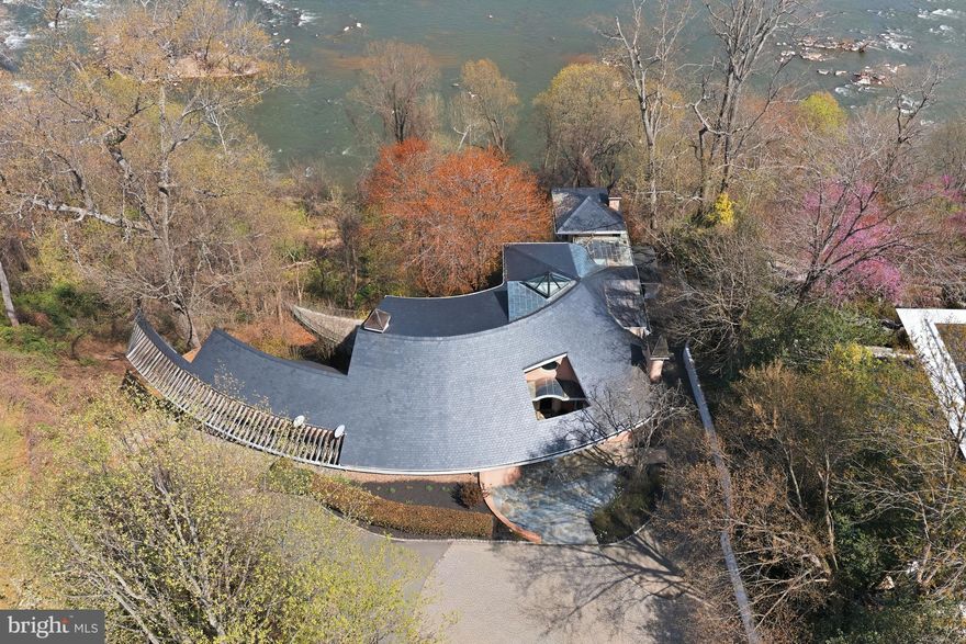 Welcome to Bella Vista, set along McLean’s Gold Coast. This extraordinary riverfront estate is perched on nearly 2.39 acres stretching directly to the water’s edge. The property commands sweeping views of the Potomac River and its dramatic cascading falls, creating a spectacular natural backdrop unlike any other in the region. A gently winding drive introduces the existing nearly 6,000-square-foot residence, thoughtfully designed to embrace the surrounding landscape. Expansive floor-to-ceiling windows across the main and upper levels capture the ever-changing river views, filling the home with natural light and connecting every major living space to the remarkable scenery beyond. The residence offers four generously sized bedrooms and five full baths, including a spacious main-level primary suite. Rich architectural elements include four fireplaces and a beautifully paneled library that creates warm, inviting spaces. Outdoors, an expansive terrace provides panoramic 180-degree views of the Potomac, offering a front-row seat to one of the area’s most captivating natural settings. Whether renovating the existing home or designing a custom riverfront masterpiece, this exceptional property presents a truly rare opportunity to create a private estate of enduring distinction. Located just minutes from Washington, D.C. and the business and shopping hub of Tysons Corner, the property offers effortless access to world-class dining, luxury retail at Tysons Corner Center, and premier outdoor recreation including Great Falls Park and Scott's Run Nature Preserve. Ronald Reagan Washington National Airport is just 15 minutes away, while the estate remains surrounded by some of McLean’s most prestigious estates.