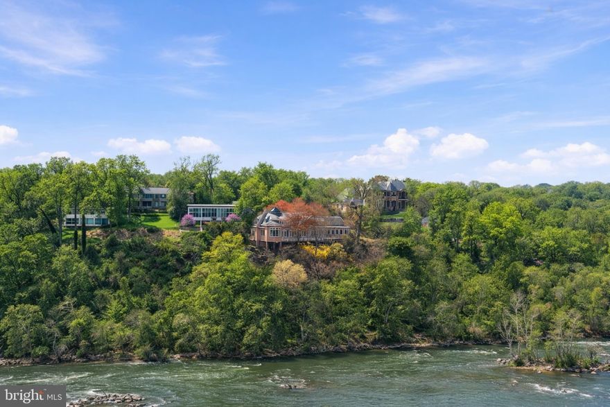 Welcome to Bella Vista, set along McLean’s Gold Coast. This extraordinary riverfront estate is perched on nearly 2.39 acres stretching directly to the water’s edge. The property commands sweeping views of the Potomac River and its dramatic cascading falls, creating a spectacular natural backdrop unlike any other in the region. A gently winding drive introduces the existing nearly 6,000-square-foot residence, thoughtfully designed to embrace the surrounding landscape. Expansive floor-to-ceiling windows across the main and upper levels capture the ever-changing river views, filling the home with natural light and connecting every major living space to the remarkable scenery beyond. The residence offers four generously sized bedrooms and five full baths, including a spacious main-level primary suite. Rich architectural elements include four fireplaces and a beautifully paneled library that creates warm, inviting spaces. Outdoors, an expansive terrace provides panoramic 180-degree views of the Potomac, offering a front-row seat to one of the area’s most captivating natural settings. Whether renovating the existing home or designing a custom riverfront masterpiece, this exceptional property presents a truly rare opportunity to create a private estate of enduring distinction. Located just minutes from Washington, D.C. and the business and shopping hub of Tysons Corner, the property offers effortless access to world-class dining, luxury retail at Tysons Corner Center, and premier outdoor recreation including Great Falls Park and Scott's Run Nature Preserve. Ronald Reagan Washington National Airport is just 15 minutes away, while the estate remains surrounded by some of McLean’s most prestigious estates.