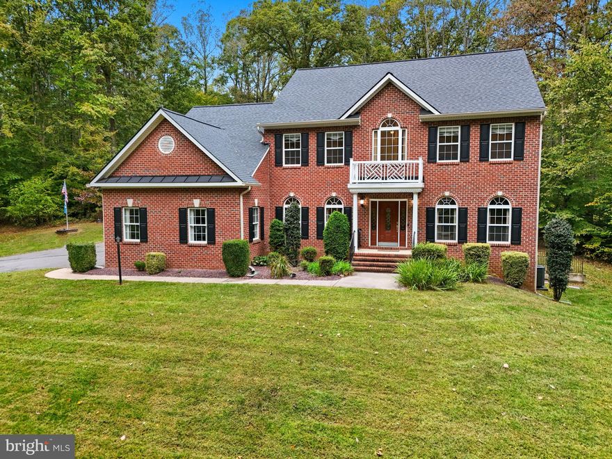 Welcome to this elegant Colonial offering over 5,465 sq ft of thoughtfully designed living space on a peaceful 3.15-acre private wooded lot—just minutes from I-95! Step inside to find a main-level owner’s suite featuring a tray ceiling, custom walk-in closet with built-ins, and a spa-inspired luxury bath. The gourmet kitchen is a chef’s dream with slab granite countertops, a large island with cooktop, stainless steel appliances, and rich cherry cabinetry—perfectly positioned between the formal dining room and sunlit breakfast nook. Entertain in style in the dramatic 2-story family room with a gas fireplace, or host more intimate gatherings in the formal living and dining rooms. Upstairs you’ll find a junior suite with private full bath, plus two additional bedrooms with a Jack & Jill bath. The fully finished lower level is a showstopper—complete with a massive rec room, wet bar, au pair/in-law suite with full bath, and a custom media room featuring a projection system and surround sound. Additional highlights include: New CertainTeed Landmark architectural shingle roof (2025), new 6” K-style gutters with gutter guards (2025), Trex deck overlooking private backyard, 20-amp EV charging station in the garage, newer HVAC system (2022), beautiful hardwood flooring and newer carpets, abundant storage throughout, ample parking for up to 8 vehicles including an attached 2 car garage, plus extended driveway space. This extraordinary home blends classic elegance with modern upgrades—offering privacy, space, and luxury. Don’t miss this rare opportunity to make this wooded oasis your next home!!