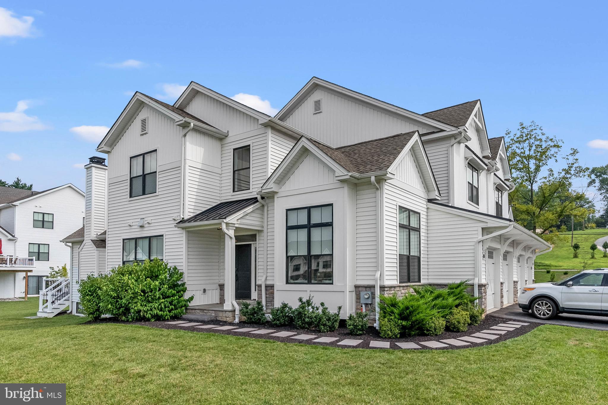 A Rare West Chester Offering. One of only four homes in Sawmill Court to feature a first-floor primary suite, this 2023-built residence offers over 4,400 square feet of refined living, including an expansive, fully finished lower level. Sunlit interiors showcase soaring ceilings, a stone fireplace rising to the rafters, and walls of Marvin windows that bathe the home in southern light. The chef’s kitchen is a showpiece with Century Carriage House cabinetry, Cambria Quartz “Skara Brae” countertops, and a full Thermador appliance suite. The primary suite is a private retreat with beamed ceilings, dual walk-in closets, and a spa-inspired bath. Additional highlights include custom built-ins, wine storage, designer lighting and tile throughout, and a study framed by a dramatic 12-foot shadow box wall. Outdoors, manicured grounds offer a tranquil setting just minutes from the cultural and dining heart of West Chester. A residence where craftsmanship, comfort, and rarity converge.