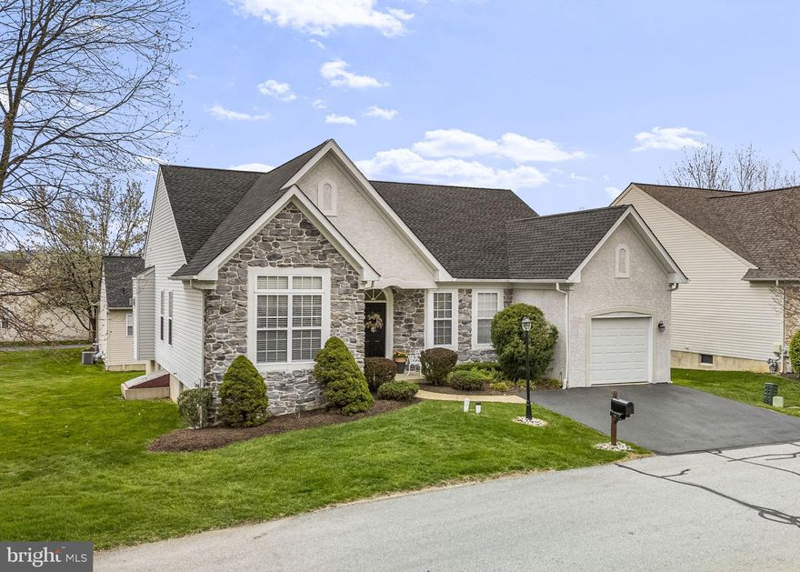 Welcome to this gorgeous, gray stone-front ranch home nestled in the desirable community of Downing Forge by the Brandywine in Downingtown. This highly sought-after 55+ active adult neighborhood offers a true resort lifestyle in one of the Main Line’s most convenient locations. The community is comprised of just 112 homes set along beautifully landscaped, tree-lined cul-de-sacs.

As you approach this impeccably maintained home, the lovely covered front porch offers just the right amount of privacy to enjoy your morning coffee while listening to the gentle sounds of birds chirping. From the moment you arrive, this inviting space sets the tone for the warmth and comfort that continues throughout the home.  As you step inside this beautiful home, you will discover a bright, open floor plan enhanced by numerous upgrades throughout. Luxurious hardwood floors and soaring 12 foot ceilings flow seamlessly through the foyer, living room, dining room, breakfast/sunroom, and both bedrooms. The elegant dining room showcases architectural columns and a tray ceiling, while the spacious living room features abundant natural light, and a cozy remote-controlled gas fireplace.

The well-positioned kitchen is designed for both function and style, offering 42” white Century Cabinets®, Corian® countertops, a center island, tile backsplash, pantry and a full suite of appliances including GE® dishwasher, microwave, and electric range, along with a Whirlpool® refrigerator. The adjoining breakfast room/sunroom, complete with plantation shutters, opens through an atrium door to a large composite deck—perfect for relaxing or entertaining.

The generously sized primary bedroom suite includes a walk-in closet and an additional sliding door closet, ceiling fan, and a private bath with an elegant vanity and walk-in shower. A comfortable secondary bedroom is complemented by a full hall bath with tub and shower.  The laundry room is equipped with a GE® Washer and a GE® Dryer, plus it features two large, custom-built white storage cabinets, offering both convenience and ample space.

The expansive finished basement provides incredible flexibility, offering a large, carpeted space ideal for a great room, exercise room, home office, and/or potential third bedroom, along with a convenient powder room. The meticulously constructed egress window fills the room with natural sunlight during daylight hours, also the egress window satisfies Caln Township’s Emergency Escape Opening Requirement if a third bedroom is desired.  There are also 2 unfinished areas in the basement offering tons of storage space and workshop area. 

The Clubhouse at Downing Forge has a monthly calendar filled with social clubs that incorporate book discussions, card games, and more. Some other established clubs include golf club, Mah Jongg club, TGIF club, and knitting club. Whether attending a luncheon hosted by the Forgers Club or joining neighbors for coffee and crafts, there’s always something fun happening at Downing Forge.  Other amenities include a 32,000 gallon – heated-out-door pool, regulation tennis courts, shuffleboard, pickleball and bocce ball. 
Downing Forge sits on the banks of the Brandywine River and borders the historic borough of Downingtown. 

It is conveniently located near fine restaurants, great shopping, parks, nature areas, trails and excellent public transportation. Plus, the Downing Forge Community is near major roadways like the Pennsylvania Turnpike, Route 202, Lancaster Avenue, and the 30 Bypass. This makes great big-city attractions in New York City and the beaches of Delaware and New Jersey accessible for weekend trips.  Closer to home, residents are about 20 minutes from King of Prussia as well as less than an hour’s drive to Philadelphia International Airport and New Castle Airport in Delaware.

Enjoy low-maintenance living and an active lifestyle in this exceptional home and community!