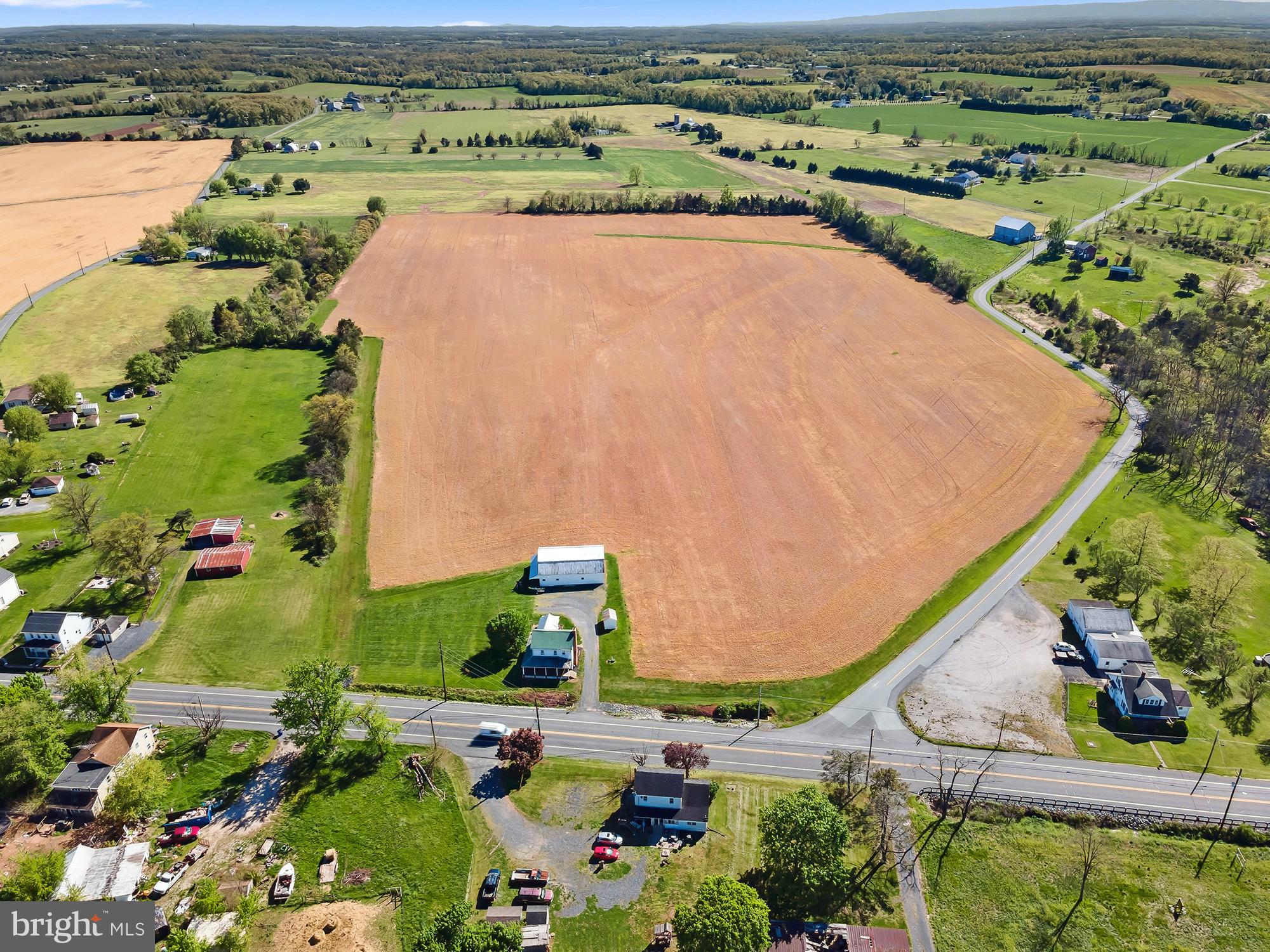 39 completely flat acres, 32 of which are tillable, await you at 3691 Baltimore Pike. This property offers so much versatility. It is currently enrolled in the Clean and Green program, however, due to township zoning, it is eligible for subdivision and could also be a mixed-use commercial, or residential site. With ample road frontage, this is a prime location for whatever your dreams may be as it is situated only a few minutes north of the heart of Littlestown and along a very popular commuter route. The property features a 2 bedroom 2 bath farmhouse that has been very well maintained  with more recent updates including windows, porch, furnace, and water heater. There is a large barn outbuilding that could easily convert to stalls with water and electric, and 2 additional smaller outbuildings that could be used for an office or storage. This property is truly a blank canvas for so many different uses and has so much potential for development, or simply keep it in crop as it currently sits. There are also approximately 3 wooded acres on the other side of Speelman-Klinger Rd with a stream.