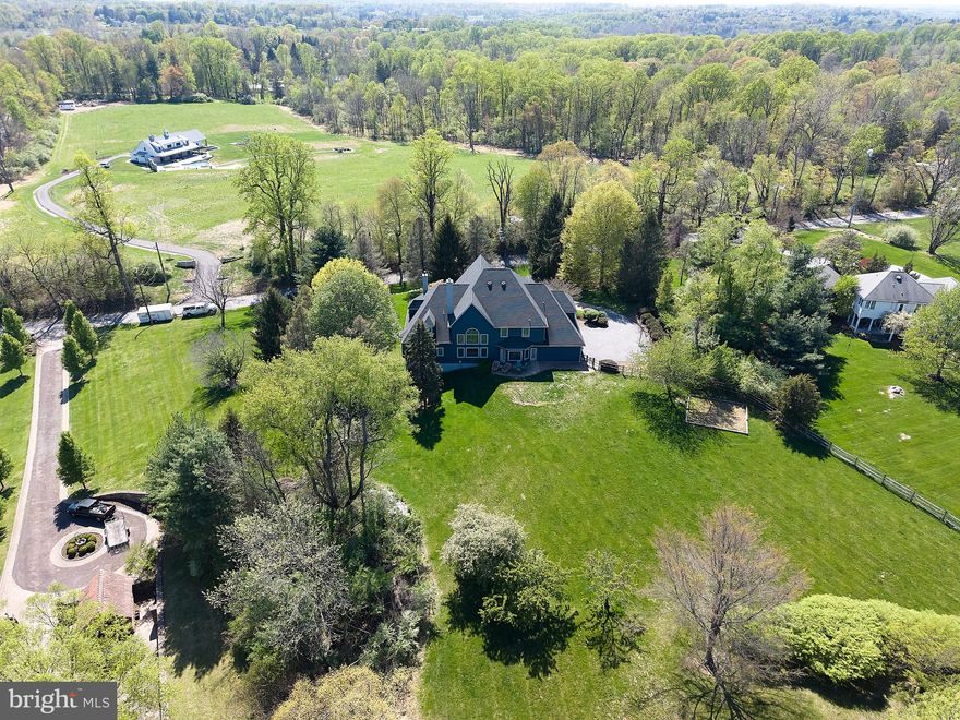 A rare offering in the heart of Chester Springs- just minutes from major roads and highways- this exceptional estate home blends privacy, elegance, and everyday flexibility. Set behind a gated driveway, the approach alone sets the tone for something truly special.  Perfectly positioned on a beautiful two acre homesite, the backyard offers and ideal setting for recreation, entertaining, or simple enjoying the peaceful surroundings and captivating views .  This impressive 6 bedroom home offers a thoughtful blend of timeless design, generous living spaces, and refined finishes throughout. Set on a picturesque lot , the property provides both privacy and convenience.  Hardwood floors extend through much of the home, complemented by detailed millwork and well-designed living spaces. The expansive kitchen features stainless steel appliances, wine refrigeration, solid wood cabinetry, quartzite countertops and a large walk-in pantry. Ample space and casual dining areas make the kitchen both functional and inviting. The main-level primary suite offers a private retreat with two walk in closets and a spacious ensuite bath.  An adjoining office with custom built ins and a gas fireplace provides flexible space for work and relaxation. Upstairs, five bedrooms offer flexible living arrangements, including a private guest or au pair suite, two bedrooms with ensuite baths and a Jack and Jill bath connecting the additional two rooms.  The exterior features usable grounds with open views, offering space for outdoor living and recreation. the 4-car garage provides parking and storage. This extraordinary property located in the Downingtown East School District with easy access to Routes 401 and 202, this home offers a combination of space, setting, and accessibility. Elegant, expansive, and ideally located- this is a home where luxury meets lifestyle in one of Chester Springs most desirable settings.