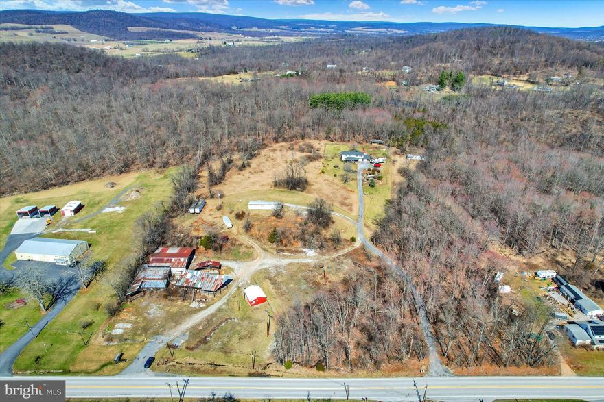 Endless possibilities await on this expansive 8.837+-acre parcel, which includes a 2-bedroom, 1-bath mobile home, multiple outbuildings, separate 24x28 insulated building currently used as an office,  a well with an impressive 150 gallons per minute capacity and a conventional septic. The property consists an additional approved building lots w/existing sandmound,  Property is zoned village which allow for many possibilities for residential or business use. Buildings are equipped with 200-amp service and access to 3-phase service, this versatile land offers a wealth of opportunities for both residential and commercial endeavors. It is conveniently located near ski and golf resorts, shopping centers, historic Gettysburg, various local attractions, and amenities, as well as major routes for an easy commute.