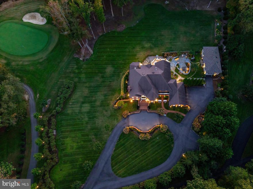Set behind a private automated gate on nearly 3 acres, this solid brick estate offers nearly 10,000 sq ft fin. space inc. a detached garage, blending resort-style living, privacy, & modern-meets-classic design. Since 2019, the home has undergone an extensive renovation, inc. plumbing, electrical, UV-protected windows, & a 3-level double door French Style elevator. A newly expanded circular paver driveway & walkways—illuminated by handmade lanterns & low-voltage lighting—wind through curated grounds featuring a "white and pastel" floral palette, Norway Spruces, & a cascading waterfall pond. While backing to the 5th hole on the member-only Golf Club, the estate maintains a deep natural buffer w/ a private 750-ft wooded walking trail & "bird sanctuary". The arrival is marked by a grand gated entrance, setting the tone for this exceptional residence. A dramatic 2-story, sun-filled foyer welcomes you, highlighted by a Schonbek chandelier, a custom double front door, & a sweeping curved staircase. Distressed maple floors & exceptional artisan-crafted millwork create a sense of cohesion & craftsmanship throughout the home. The main level unfolds with beautifully appointed living spaces designed for both elegant entertaining & everyday comfort. A formal parlor w/ a fireplace offers a refined gathering space, while an artisan-crafted, richly paneled library features a coffered ceiling, a Napoleon Style lighting fixture, & a stately built-in desk. The private dining room is enclosed by a custom metal & glass wall w/double doors, creating an intimate yet dramatic setting for hosting dinners for 12+  guests. The family room—featuring pocket doors & surround sound—is anchored by a striking marble fireplace. It flows seamlessly into the kitchen & opens to private stone balconies, beautifully blending indoor and outdoor living. The chef’s kitchen is both sophisticated and functional, featuring a large central island, premium stainless-steel appliances by Viking and Sub-Zero, a warming drawer, integrated specialty appliances, and 2 climate-controlled walk-in pantries. The sunroom is the most beloved space in the residence. With soaring cathedral ceilings, a dramatic 72-inch linear steel fireplace, & panoramic views of the fairway, it offers an extraordinary retreat. Completing the main level-a spacious mudroom & 2 elegant half-baths, including a distinctive powder room finished w/Belgium blue stone flooring. The French Style 3-floor elevator leads to the upper level featuring 4 spacious bedrooms & three full baths. Enjoy the primary suite, w/a sitting room, double-sided fireplace, oversized closets, & a spa bath w/ marble, mosaic tile, steam shower, &  Schonbek lighting (laundry hookups in-suite). 2 additional bedrooms share a Jack & Jill bath w/stamped marble floors, while the 4th guest suite has a private luxe jacuzzi bath. The walk-out lower level includes a family room w/a fireplace, an executive office w/custom woodwork &  dedicated mini split HVAC, a private guest suite w/ a rainfall shower, & a fitness room w/ a sauna & red-light therapy. It is anchored by a custom mahogany bar w/ black granite flooring, a tap pump, 200+ bottle wine storage, & a kitchenette area. This level features LED-lit steps, Coretec flooring, a large covered stone patio ideal for outdoor gatherings, a spectacular laundry center, specialized utility rooms, and 2023 custom-cabinetry storage. The home offers unparalleled infrastructure: a 2019 well with 3 HP pump, dual Generac generators, four HVAC systems with five zones and mini-splits, instant-hot water, and a certified CertainTeed Presidential roof. A 2024 AV rack seamlessly controls Sonos, Lutron, and battery-backed Ubiquiti Wi-Fi. The 2,000 sq. ft. (est) detached stone building, boasts soaring bays, a cargo lift, EV charging, and natural stone detailing—a collector’s dream for cars, boats, or hobbies. Resort-style amenities:pools, tennis/pickleball, playground, walking paths & picnic area.