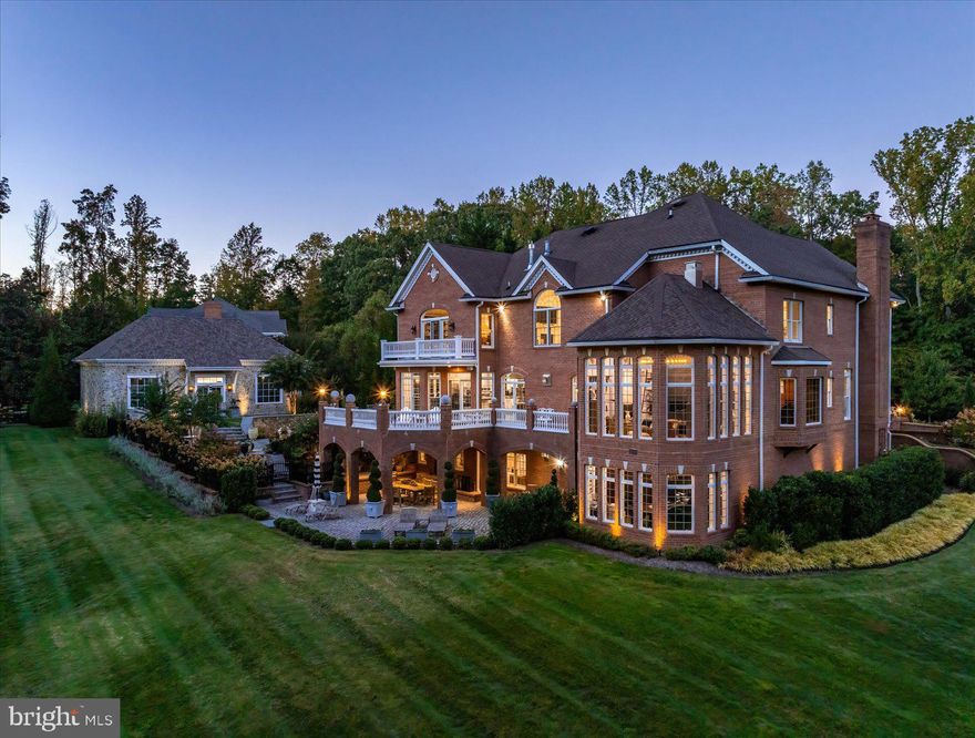 Set behind a private automated gate on nearly 3 acres, this solid brick estate offers nearly 10,000 sq ft fin. space inc. a detached garage, blending resort-style living, privacy, & modern-meets-classic design. Since 2019, the home has undergone an extensive renovation, inc. plumbing, electrical, UV-protected windows, & a 3-level double door French Style elevator. A newly expanded circular paver driveway & walkways—illuminated by handmade lanterns & low-voltage lighting—wind through curated grounds featuring a "white and pastel" floral palette, Norway Spruces, & a cascading waterfall pond. While backing to the 5th hole on the member-only Golf Club, the estate maintains a deep natural buffer w/ a private 750-ft wooded walking trail & "bird sanctuary". The arrival is marked by a grand gated entrance, setting the tone for this exceptional residence. A dramatic 2-story, sun-filled foyer welcomes you, highlighted by a Schonbek chandelier, a custom double front door, & a sweeping curved staircase. Distressed maple floors & exceptional artisan-crafted millwork create a sense of cohesion & craftsmanship throughout the home. The main level unfolds with beautifully appointed living spaces designed for both elegant entertaining & everyday comfort. A formal parlor w/ a fireplace offers a refined gathering space, while an artisan-crafted, richly paneled library features a coffered ceiling, a Napoleon Style lighting fixture, & a stately built-in desk. The private dining room is enclosed by a custom metal & glass wall w/double doors, creating an intimate yet dramatic setting for hosting dinners for 12+  guests. The family room—featuring pocket doors & surround sound—is anchored by a striking marble fireplace. It flows seamlessly into the kitchen & opens to private stone balconies, beautifully blending indoor and outdoor living. The chef’s kitchen is both sophisticated and functional, featuring a large central island, premium stainless-steel appliances by Viking and Sub-Zero, a warming drawer, integrated specialty appliances, and 2 climate-controlled walk-in pantries. The sunroom is the most beloved space in the residence. With soaring cathedral ceilings, a dramatic 72-inch linear steel fireplace, & panoramic views of the fairway, it offers an extraordinary retreat. Completing the main level-a spacious mudroom & 2 elegant half-baths, including a distinctive powder room finished w/Belgium blue stone flooring. The French Style 3-floor elevator leads to the upper level featuring 4 spacious bedrooms & three full baths. Enjoy the primary suite, w/a sitting room, double-sided fireplace, oversized closets, & a spa bath w/ marble, mosaic tile, steam shower, &  Schonbek lighting (laundry hookups in-suite). 2 additional bedrooms share a Jack & Jill bath w/stamped marble floors, while the 4th guest suite has a private luxe jacuzzi bath. The walk-out lower level includes a family room w/a fireplace, an executive office w/custom woodwork &  dedicated mini split HVAC, a private guest suite w/ a rainfall shower, & a fitness room w/ a sauna & red-light therapy. It is anchored by a custom mahogany bar w/ black granite flooring, a tap pump, 200+ bottle wine storage, & a kitchenette area. This level features LED-lit steps, Coretec flooring, a large covered stone patio ideal for outdoor gatherings, a spectacular laundry center, specialized utility rooms, and 2023 custom-cabinetry storage. The home offers unparalleled infrastructure: a 2019 well with 3 HP pump, dual Generac generators, four HVAC systems with five zones and mini-splits, instant-hot water, and a certified CertainTeed Presidential roof. A 2024 AV rack seamlessly controls Sonos, Lutron, and battery-backed Ubiquiti Wi-Fi. The 2,000 sq. ft. (est) detached stone building, boasts soaring bays, a cargo lift, EV charging, and natural stone detailing—a collector’s dream for cars, boats, or hobbies. Resort-style amenities:pools, tennis/pickleball, playground, walking paths & picnic area.