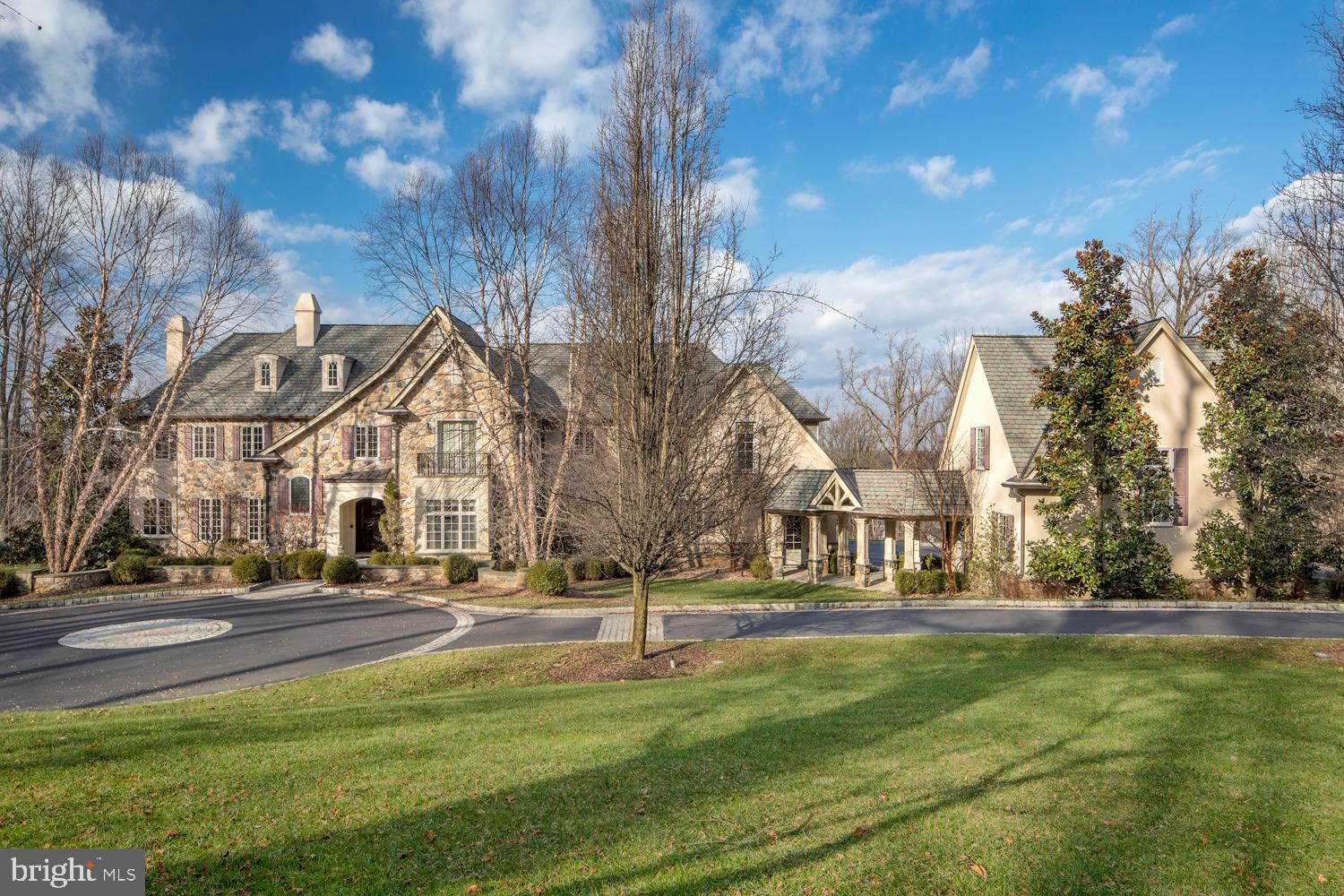 Feast your eyes on this one-of-a-kind private hilltop villa in desirable Conshohocken where magnificence abounds! This custom built jewel, lovingly created by current owners in 2008, is a study in luxurious, timeless design. Nestled on lush landscaped grounds spanning 4 acres, the grand yet welcoming stone estate presents a front motor court & heated drive, 5 generous bedrooms, 7 high-end baths, and over 10,000 sq ft of warm, inviting spaces to entertain. Outdoor areas afford a breathtaking setting for gatherings with family & guests, boasting expansive terraces for alfresco dining and a sparkling resort pool with spa. Step inside the stunning foyer and marvel at the exquisite custom craftsmanship, woodwork and designer touches found throughout. Gorgeous crown moldings & millwork, elegant archways & fireplaces, beautiful tile & hardwood floors, recessed lighting & other refined elements enrich the interiors that are bathed in natural light. The host will have every convenience with a spacious formal living room, piano room, butlers pantry with wet bar, and gracious dining room providing a perfect backdrop for large or intimate gatherings. For the chef, a fully-equipped gourmet kitchen is adorned with top-of-the-line stainless steel appliances including an integrated Sub-Zero fridge & Miele dishwasher, ample custom cabinetry, sleek countertops & huge center island with seating. A sunny breakfast room rests nearby for morning coffee and poolside views. Slide open the glass doors and enjoy the tranquil patio with fireplace, grill, and vibrant nature scenes reflecting a sense of calm. Lounge & watch TV in the lovely family room with vaulted ceilings & full bar, and get some reading or work done in the handsome paneled library/office. Unwind in your well-appointed primary suite featuring a gas fireplace, his & her walk-in closets, and spa bath wrapped in upscale design. Guest suites are as impressive and all en-suite, offering sizable closets & proximity to the 2nd-floor game/family room with a wet bar & bonus office. The whole family will love the day-lit walkout lower level, a recreational haven with a billiards room, 2nd kitchen with wet bar, wine fridge & dishwasher, state-of-the-art 12-seat theatre with separate kids lounge, plus an exercise room & sauna with steam shower. But there is nothing better than taking a dip in the heated Gunite saltwater pool, relaxing in the hot tub & gazing out at the scenic vistas. Topping the allure is an attached 3-car garage, detached 2-car garage, unfinished guest house, central AC & a backup generator. This meticulously-maintained family & entertainers dream in a prime location will ensure lasting appeal, memories & comfort for decades to come.