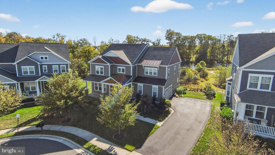 Presenting a meticulously maintained Winslow Model home by Beazer Homes, located on a premier cul-de-sac lot with tranquil views of Willow Lake in The Grove at Willowsford. This distinguished residence offers 5 bedrooms, 4.5 bathrooms, and an array of high-quality upgrades in one of the area’s most sought-after communities.

Situated on a premium lot that backs to Willow Lake, mature trees, and common areas with walking trails, this property features outstanding vistas of local wildlife, including over fifteen bird species, along with serene sunsets and moonlit evenings.

The owner has invested more than $150,000 in enhancements such as invisible fencing, a lawn irrigation system, extensive hardscaping, custom flower beds, ornamental grasses, evergreen trees, and additional landscaping elements. Further notable improvements include a soundproof media room, integrated 5.1 sound systems in the family and media rooms, a monitored security system with RING doorbell and cameras, wainscoting throughout, hardwood flooring on the main level and stairways, LVP flooring on the upper and lower levels, under-cabinet lighting, and a fully equipped basement in-law suite with kitchenette, fifth bedroom, full bath, walk-out access to the patio and gardens overlooking the lake.

Main-Level, welcomes you with beautiful wood floors and a two-story ceiling. The formal dining room, featuring a wall of windows, connects to the butler’s pantry. The gourmet kitchen includes quartz counters, a walk-in pantry, gas cooktop, expansive cabinetry with under-lighting, a large quartz island, stainless steel appliances, wall oven, refrigerator with ice maker and water dispenser. The breakfast area extends to a covered deck for morning or evening relaxation while enjoying lake views. The open concept family room features a gas fireplace and built-in shelving. Additional amenities comprise a side-load garage opening to a mudroom with built-ins and a spacious laundry room with cabinetry and folding space.

Upper-Level, the primary suite offers a sitting room, two walk-in closets, and a modern bathroom with a dramatic freestanding soaking tub, separate walk-in shower with bench, dual vanities, and a dedicated makeup area. Two secondary bedrooms feature walk-in closets and individual vanities, sharing a Jack & Jill bathroom, while the fourth bedroom is an en-suite with a private bath.

Lower-Level, walk-out provides a sizable recreation room, fifth bedroom, dual access full bath, bright full-size windows, and a kitchenette with wet bar and stainless steel refrigerator. Utility Room include HVAC, sump pump and a 75-gallon water heater. Additionally enjoy the substantial storage room.

Outdoor encompasses a charming covered front porch, rear covered deck, extensive hardscaped patio adjoining beautifully landscaped gardens, lake views, walking paths, and a nearby pavilion.

Willowsford offers unparalleled community features across 4,000 acres, blending farming and luxury living. Residents have access to forty miles of trails, ponds, tot lots, swimming pools, fitness centre, splash pad, dog parks, sledding hill, meadows, parks, club house, boat house, water equipment rentals, pool house, Willow Lake patio and fire pit, town greens, beach volleyball, bocce ball court, and the Willowsford Farm House.