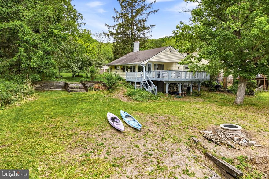 Over a small bridge takes you to a unique and private Riverfront setting. . Bridge Four is a 17 home enclave with exquisite views of the Delaware, without being on River Road.
44 Bridge Four is a cozy 2 bedroom, 1 bath cottage sited on a half acre lot, with a two car garage. The living room has a wood burning fireplace, to take the chill off the evenings and gleaming hardwood floors. When you step out onto the large deck overlooking the River,, you’re transported to a tranquil moment that allows the stress to melt away. Next to the River, is a fire pit and private steps down to the kayak launch.
Also, Seller has architectural drawings of a two story, multi deck addition, that was approved by the township. These would be available to any interested party. The new Owner would have to reapply for the township permits.