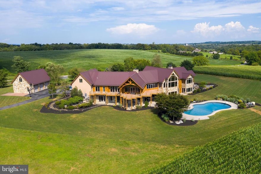 CLICK THE VIDEO ICON TO TOUR THIS HOME.  This magnificent home with nearly 11,000 square feet of living space is situated perfectly on a private 87 acre lot that includes 4 separate pastures.  This one-of-a-kind home with 6 bedrooms and 5.5 bathrooms features 4 stone fireplaces, stunning beech wood flooring, and beautiful exposed beams and soaring ceilings throughout. Open concept floor plan flows effortlessly between great room, dining space, and a gourmet chef's eat-in kitchen which features granite countertops, double oven, and new cooktop.  Spacious master suite with vaulted beam ceiling, sitting area, large walk-in closet, and walk-out patio features a beautiful master bath with soaking tub, tile shower, and dual vanities with recessed lighting.  Additionally the home includes family room with wet bar, library with custom built-in shelving, and mud room.  Finished lower level has a summer kitchen and theater room with tiered seating that includes equipment. Enjoy breathtaking views of the sprawling land from the large rear deck, patio, and heated in-ground pool, which provide a picturesque setting for entertaining.  The professionally landscaped lawn enhances the natural beauty of the lot, and creates lots of shade from the mature trees.  There is ample parking between the attached 3-car garage, and additional detached 3-car garage.