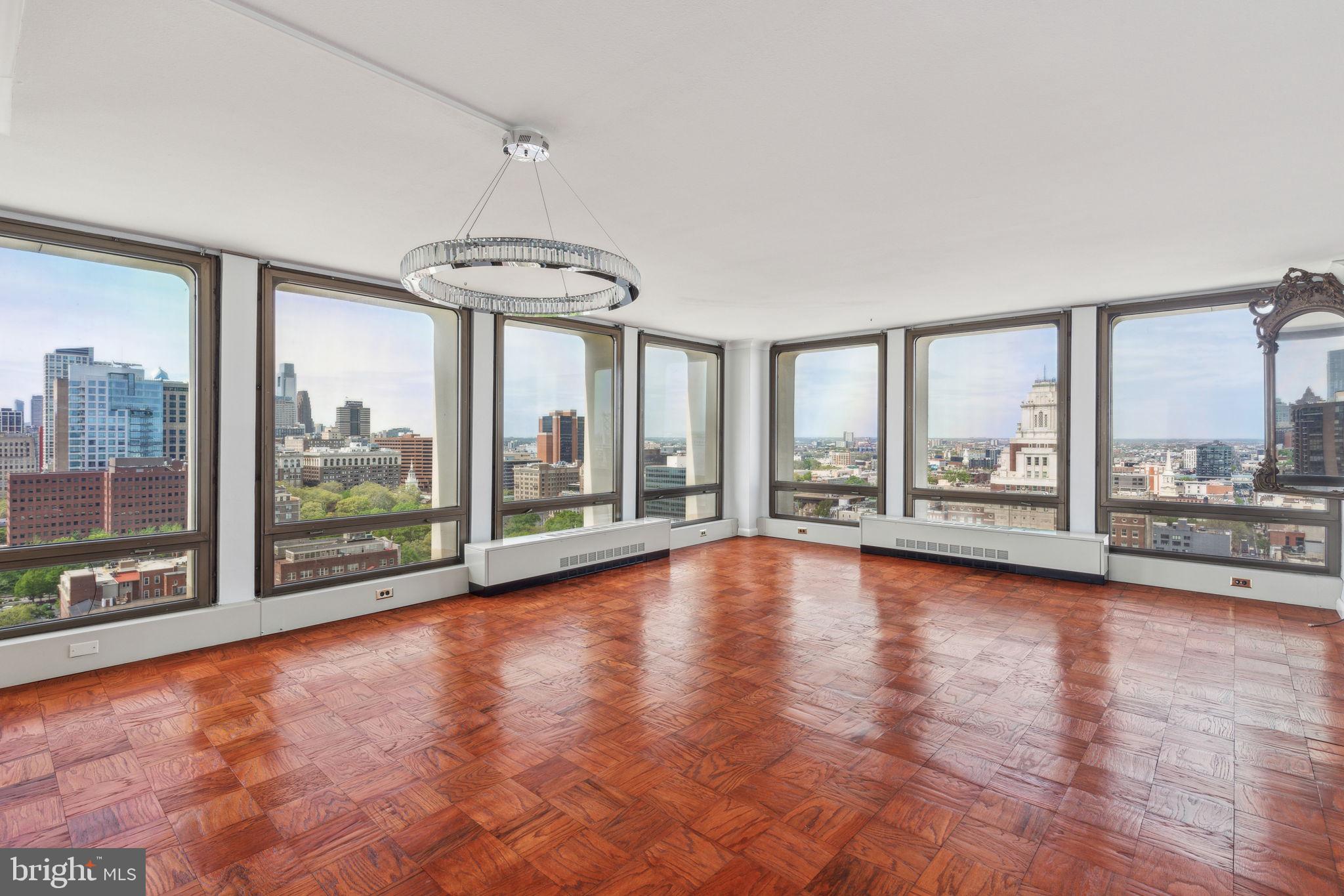 Beautifully maintained and updated corner two bedroom with unobstructed views of Center City and the Ben Franklin Bridge on a high floor of Society Hill Towers. This sun-soaked home features floor-to-ceiling windows in all living spaces and bedrooms, custom finishes, high-end updates, and parquet wood flooring throughout. Enter through a foyer with large coat closet and custom light panel into the bright and spacious great room. Ideal for entertaining, the expansive great room enjoys ample space for various living and dining furniture layouts as well as two walls of windows providing beautiful natural light and see-forever northwest city views. Adjacent is the fully updated kitchen with sleek modern wood cabinetry, solid surface black countertops, glass tile backsplash, custom under-cabinet and accent lighting, stainless steel sink with disposal, marble tile floor, and new high-end stainless steel appliances including a wood-paneled Liebherr refrigerator, Wolf oven and gas range with Broan hood, Bosch dishwasher, and built-in Sharp microwave. The spacious primary bedroom boasts more sunset Center City views, a laundry room with brand new stacked Bosch washer/dryer, and a fully renovated ensuite bathroom with designer marble tiling throughout, a Brazilian quartzite vanity with vessel sink, and an open shower with rainfall and handheld shower heads. The light-filled second bedroom is generously sized and enjoys a large wall closet and use of a fully updated hall bathroom with more designer marble tiling, another Brazilian quartzite vanity, and a large soaking tub with shower head. Additional home highlights include two additional closets in the hallway leading to the bedrooms and custom built-in shelving in all closets, recessed lighting in the bathrooms, custom light fixtures throughout that are all dimmable, crown and baseboard moldings, and brand new outlets and electric panel. Residents of Society Hill Towers enjoy a 24-hour doorman and all utilities plus basic cable. Access to the building's outdoor seasonal pool, fitness room, storage lockers, and parking in the building's underground garage are available for an additional fee. Also, there is an on-site Philly Car Share, a coin operated laundry room in the basement, and a shopping plaza on site with a market, dry cleaner, beauty salon, and one of Philly's most acclaimed restaurants, Zahav.