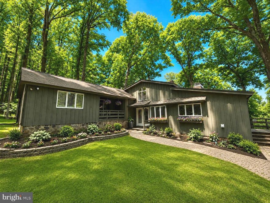 Overlooking nearly three private acres of mature landscape and treetop scenery within the sought-after New Hope-Solebury School District, this spectacular mid-century modern home offers a rare combination of privacy, elevated views, and quick access to the best of Bucks County living. Set at the end of a quiet cul-de-sac atop Solebury Mountain, the peaceful setting feels removed while remaining just minutes from downtown New Hope, Lambertville, Doylestown, and the area’s beloved river towns, restaurants, galleries, and shops. Inside, warm wood flooring extends across the home, complemented by Italian stone floors at the entry and within the kitchen. The spacious living area features soaring 16’ ceilings and is filled with natural light from expansive floor-to-ceiling windows centered around a stunning oversized stone, wood-burning fireplace. Newly installed oversized Andersen sliding doors lead directly to the rear deck, creating an easy connection to the outdoor living space and elevated surroundings. Pocket doors lead to the dining room, which offers exceptional space for entertaining and access to the deck, while the refreshed kitchen combines style and function with butcher block countertops, double ovens, electric cooktop, peninsula seating, an eat-in area, and abundant pantry storage. A dedicated laundry room with additional storage and coat closet sits just off the kitchen, along with a conveniently located powder room. Upstairs, all bedrooms are generously sized and thoughtfully designed. The primary suite includes private deck access, a walk-in closet, and an ensuite bath with double vanity and shower. A second bedroom features skylights and built-ins, while the third bedroom opens directly to its own balcony. A recently renovated hall bath with tub and shower serves the secondary bedrooms, while multiple oversized closets provide impressive storage capacity. Updated lighting, generous room sizes, and the home’s beautiful architectural lines give the interior an inviting, airy feel. The walk-out lower level offers additional flexibility for entertaining with a full bar and recreation area, a wood-burning fireplace, and a fourth bedroom with full en-suite bathroom and walk-in closet, ideal for an in-law suite, guest quarters, home office, gym, or creative studio. Newly installed dual-zone HVAC, whole-home automatic generator, and beautiful views from every room complete this breathtaking property, offering a compelling blend of style, space, and location in one of the area’s most desirable settings.