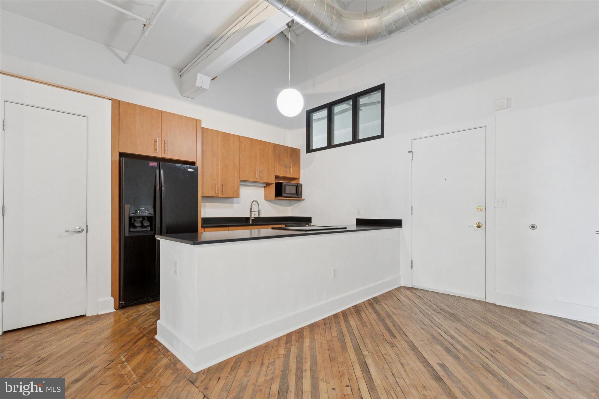 Bright and spacious 1-bedroom, 1-bath loft in the sought-after Byrne Lofts in Phoenixville. This updated unit is one of only four in the building to feature a true loft-style bedroom —making it one of the most unique layouts available.
Enjoy soaring 15-foot ceilings, exposed beams, and oversized industrial-style windows that fill the space with natural light. The home also boasts beautifully refinished original maple hardwood floors and an open-concept living area. The kitchen is equipped with custom maple cabinetry and a large island, ideal for both cooking and entertaining.
The community offers a fitness center, resident lounge, and is just a short stroll to the restaurants, shops, and nightlife of Downtown Phoenixville.