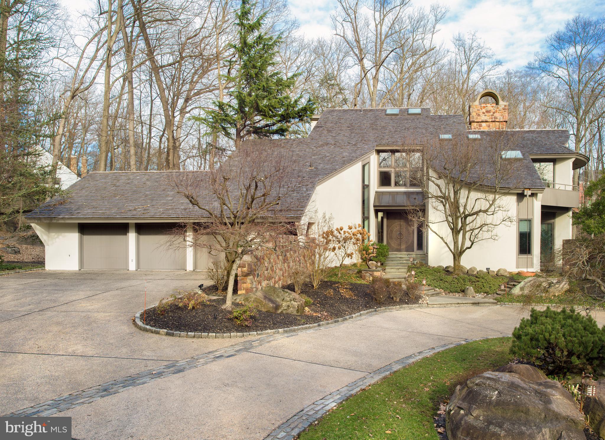 Remarkable contemporary home nestled on a private scenic nearly 4 acre parcel conveniently located in the TE school district of picturesque Chester County, PA only minutes away from Devon train station and heart of Wayne. With every detail considered, this unique 6 bedroom, 7 full and 1/2 bath home was custom built by the partnership of architect Mark Stanish and Pohlig Builders and offers luxurious amenities including a most relaxing pool and spa with waterfall set in a woodland paradise with stream. Light fills every inch of the home with extraordinarily oversized windows drawing in not only the sun but the breathtaking views of the surrounding landscape. A soaring 3-story foyer sets the bar of expectation upon entrance with gleaming travertine marble flooring that seamlessly flows into an open piano area bathed in sunlight by a 3-story monumental window. The right of the foyer steps down into a spacious living room with oak hardwood flooring, granite hearth gas fireplace with historic carved stone mantle surround and sliding doors leading to a slate terrace. A cozy office/study with privacy pocket door offers oak hardwood flooring, circular accent wall, steps leading to the wine cellar, and 3 window slider door to slate terrace. Ahead of the foyer is the dining room with marble flooring, floor to ceiling mirrored wrap around wall and oversized sliding doors leading to a viewing deck providing a breathtaking visual of the surrounding woodlands. The custom kitchen is every chef s dream with plenty of countertop prep space, ample cabinetry storage, Gaggenau appliances including gas cooktops, grilling station, and an induction cooktop with range hood, Bosch dishwasher, double oven, and Sub-Zero refrigerator/freezer and ice maker. A breakfast room sits adjacent to the kitchen with glass vaulted sunroom, windows on all walls and easy access to the slate terrace and grilling area. Taking two steps down from the kitchen, enter a panoramic family room with soaring 18 foot oak paneled vaulted ceiling and windows, built-in oak cabinetry, stone wall with gas fireplace, and sliding door leading to deck. Ascending the stair to the second floor, find a glass bridge leading to a private and luxurious master bedroom suite with circular window wall, outdoor deck, and 14 foot heated cathedral ceiling. The master bath is well appointed with two person Jacuzzi tub with Rojo Alicante marble tile surround, heated flooring, and two person seated shower. Four additional bedrooms, one currently used as an office, can be found on the second level, each with ensuite bath, as well as an 8x10 foot fully paneled cedar closet with built-ins. The third level offers an au pair suite overlooking the foyer, with ensuite bath, sitting area, and private deck. The lower level is perfect for additional family and guest entertaining, providing access to a home theater with fireplace, bar with custom cabinetry and fully equipped kitchen, authentic colonial brick wine cellar with custom oak 550 bottle racking, wine tasting room with wood burning fireplace, and exercise room with mirrored walls and full bathroom. Truly a one of a one of a kind home offering exceptional living for the most discerning buyer.