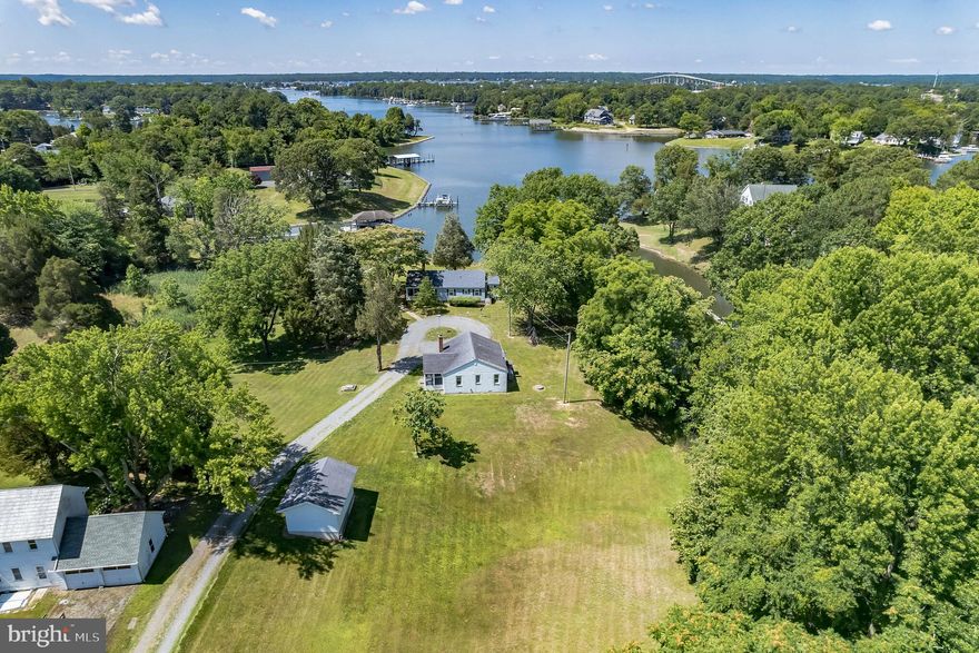 Welcome home! Enjoy the views sitting on a picturesque knoll overlooking the tranquil waters of St. Johns Creek. Located on the point of land and water considered Lusby Cove, this property has been treasured by the family for many years and offers a truly unique living experience.
 Still in its original state of interior design, the 3 bedroom 1 bath home takes you back to a  time of simple living and bygone days on the water. The hardwood floors are red oak, sourced from a bowling alley. The kitchen, dining, and living room were the center of home life.  Outside, the property offers a scenic view of  St Johns Creek.  
The 60 ft pier has 1 boat slip and water faucets, 2 sets of 120v receptacles plus 220 v at the end of the dock for a future boat lift.   A nice protected water harbor just minutes by boat to  Solomons, the Patuxent River, and the Chesapeake Bay. A great location for boating, fishing, crabbing, kayaking, and swimming.
       Offering a peaceful and quiet retreat, this property presents an opportunity for multi-generational living or potential rental income.  Nearby, the second residence built in 1956, features 2 bedrooms and 1 bathroom, providing ample space for comfortable living. From the living areas and enclosed porch, you can catch glimpses of the water.  A shared well services both homes and there are two separate septic systems. 
Adjacent to the second home is a vacant lot that provides additional space and potential. This lot includes a garage-style storage building.  Access to all parcels is via the driveway which is owned by the waterfront parcel (blue house) to Ed Joy Rd.
The combined acreage of all parcels is just under 2 ½ acres, providing ample room for outdoor enjoyment. Nature enthusiasts will delight in the abundant birdlife and wildlife that call this area home. No recorded covenants or restrictions that the seller is aware of.  Sold As is With some care and attention, this gem could shine. Now is the perfect time to prepare for Spring and Summer enjoyment.
