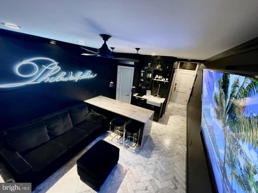 ***Owner is offering an unheard of 1.99% Seller financing for this home.****  Here is your chance to own THE quintessential, luxury, fully furnished and stocked, one-of-a-kind Pied-a-Terre studio Condo in the heart of Center City. The owner renovated this unit in 2020 with top-of-the-line features and appliances so that you can move in and not do anything to enjoy a comfortable, chic city dwelling. The renovations include Herringbone Italian marble flooring throughout, a central Quartzite waterfall peninsula, and diamond glass quaker style and space efficient custom storage cabinets. The appliances include a built-in KitchenAid refrigerator/freezer, a sharp flush drawer microwave, Fisher & Paykel dishwasher, Electronic remote-controlled blinds, and a built in 86” LG TV with Bose sound system. Central to this unit is a custom neon sign done by famed local artist Eric Rothwarf; you can find his work all over the city including Wilder restaurant, the Divine Lorraine Hotel, and Monk’s Café to name a few. What a unique touch. The bathroom is to die for, with a Koher fully electronic toilet with motion controlled,  heated seat AND bidet customized for two people, floor to ceiling navy subway tile, and a cast iron soaking tub, all enclosed by a stylist barn door entrance. This unit includes all furnishings including American Leather queen+ size couch with pull out memory foam Tempur-Pedic mattress and matching ottoman, two Safavieh Couture bar stools, glasses, dishes, chic silverware and all necessary household items. Literally, you can move in with just your clothes.  All utilities are included in the Condo fee.  There is on-site 24/7 staffed concierge front desk and on site security. There is also an on-site staffed management office. Located in the Avenue of the Arts, adjacent  to Broad and Locust Streets with a walk score of 99 and a ride score of 100,  you are walking distance to all the performance venues  Broad St south of city hall has to offer, with scores of restaurants and high-end shopping. With Patco and Septa train lines literally outside your door, access to this building is a breeze. There is a convenient fitness center, community room, and bike storage room in the basement. If you’re looking for Luxury and convenience in your city living experience, this is the place for you.