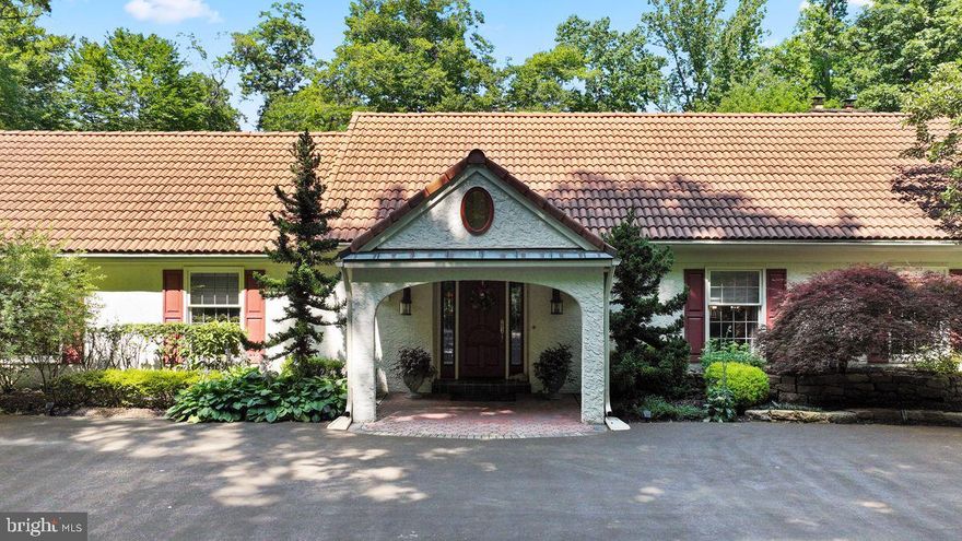 Welcome to 9 Hunt Club Lane located in the heart of Radnor Hunt Country in Malvern, Willistown. Down a long drive and through the gates one is greeted by a single floor contemporary home complete with Spanish tile roof and situated on 4.2 acres of lush landscaping and expansive lawns and boarded by a small creek. This 5800 sf home features one floor living at its finest. A large entry hall greets you and is flanked by a formal power room and a oversized coat closet. The left side of the home features a large formal living room with vaulted ceilings, hardwood floors, a gas fireplace (which can be converted back to wood) custom built-ins, and 2 sets of glass French doors leading to a beautiful sunroom with vaulted ceilings that overlooks the rear yard and woods beyond.  There's a private hall that leads to the primary suite. At the end of the living room is a guest suite complete with private bath, sitting room with a large bank of closets and a separate bedroom. To the right of the foyer is the dining room which easily seats 12-16 people with French doors to the adjacent solarium with built-in bar. The kitchen is a cooks dream with top-of-the-line appliances all in stainless steel and beautiful stone counters. The family room is finished with hardwood floors, high ceilings and custom built-ins for extra storage. Additional sliders give access to the rear terrace overlooking the free form pool and separate spa. There is a mudroom off the family room with laundry area and a back staircase to a 3rd bedroom with a full bath and large cedar lined walk-in closet. This area also has access to the 3-car garage with extra room for storage.
Back to the foyer and down the hall is the primary suite with a cream wall to wall carpet, a raised sitting area with hardwood floors and gas fireplace (can be converted back to wood) a large walk-in closet and a spacious bath with an oversized shower and separate jetted soaking tub. Completing this suite, a set of glass doors to the rear terrace for easy access to the pool area. From the foyer, there is a set of stairs that takes you to a lofty office space. 
The full basement is unfinished and houses all the mechanicals and extra storage. This home has 6 HVAC zones for individual comfort and a backup generator. This home is in pristine condition and truly a special retreat with easy access to major highways, shopping and fine dining establishments.