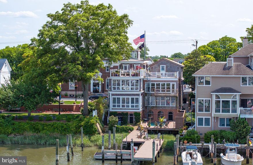 Introducing 117 Front Street, one of historic Lewes’ hidden gems. This stunning canal front home is discreetly tucked away yet central to all that Downtown Lewes has to offer. This exquisite 3 bedroom, 3.5, bath, plus flex space residence retains its historic charm while seamlessly marrying a variety of modern updates on 4+ levels of living spaces. The recently remodeled kitchen is tastefully appointed with sleek custom designed cabinetry offering an abundance of storage, quartz counters, intricate mosaic tiled backsplash, elegant lighting, commercial grade appliances and rustic beamed ceilings. The dining room has been updated with custom cabinetry and shelving throughout creating a comfortable setting for entertaining. The sitting area and living area are connected by a stylish fireplace that creates the most welcoming ambiance. The floor to ceiling windows in the living area flood the rooms with natural light and offer captivating views of the canal. The property’s spacious bedrooms can be found on the main level, 3rd level and lower level and each feature a private ensuite bath. The flex space includes two Murphy beds for overflow guests. The top level of the home, reminiscent of a Lantern Room, offers an ideal space to escape and take in a good book while relaxing on the comfy custom cushions. The most discerning buyer will be amazed at the luxurious outdoor living spaces including a screened porch, patio and gardens surrounding the heated salt-water swimming pool, private dock including 4 slips, and rooftop deck offering unparalleled views of the canal. This beautiful home is further enhanced by a magnitude of distinctive architectural features including archways, original exposed beams, Mansard roof, and stone walls to name a few. Included in the sale is a charming commercial space offering superb in-town Lewes exposure on Front Street and rental income to the owner, or utilize this space for your own private office. This property is truly one-of-a-kind and is a must see!